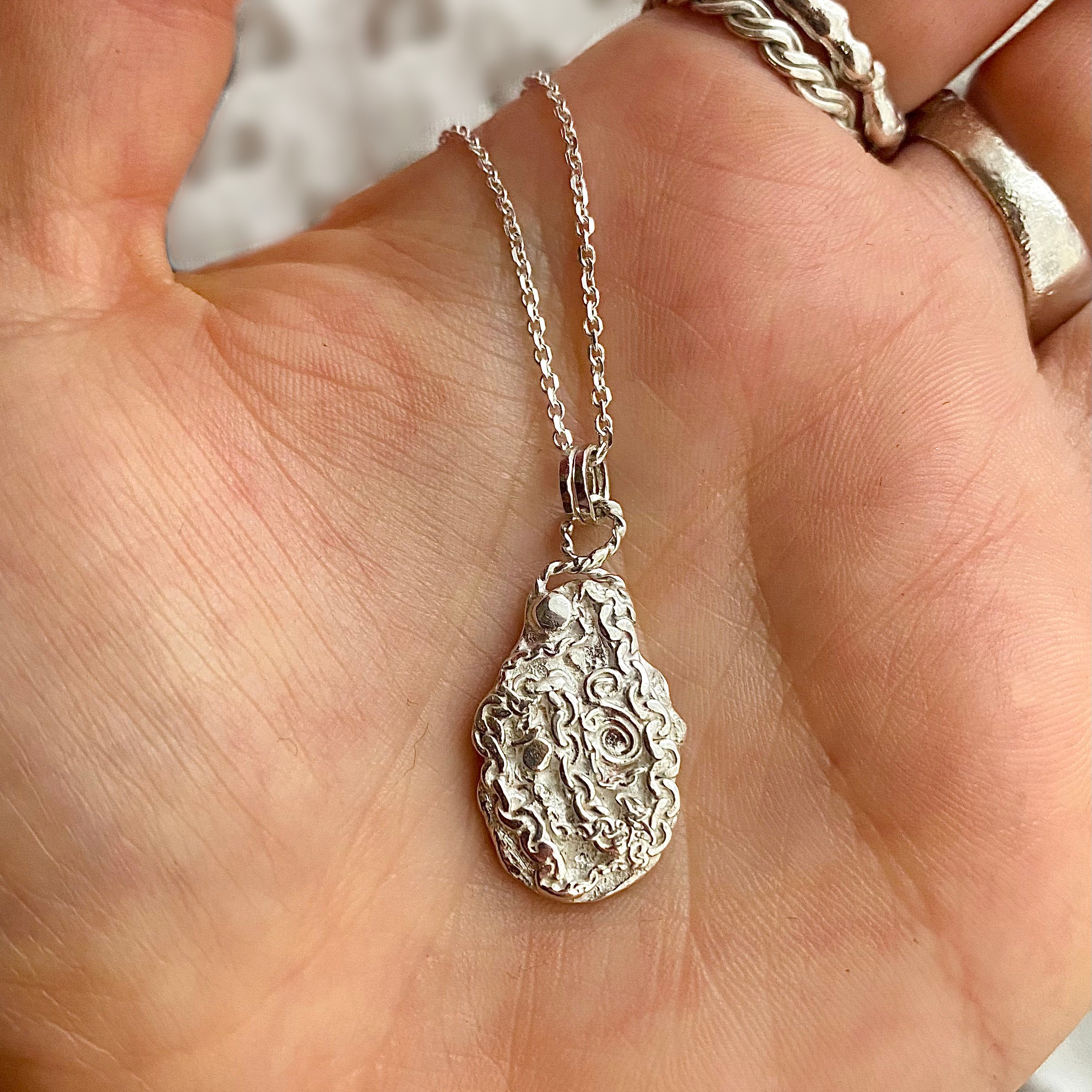 Oval Silver Chain Beachcomber Pendant on hand.jpg