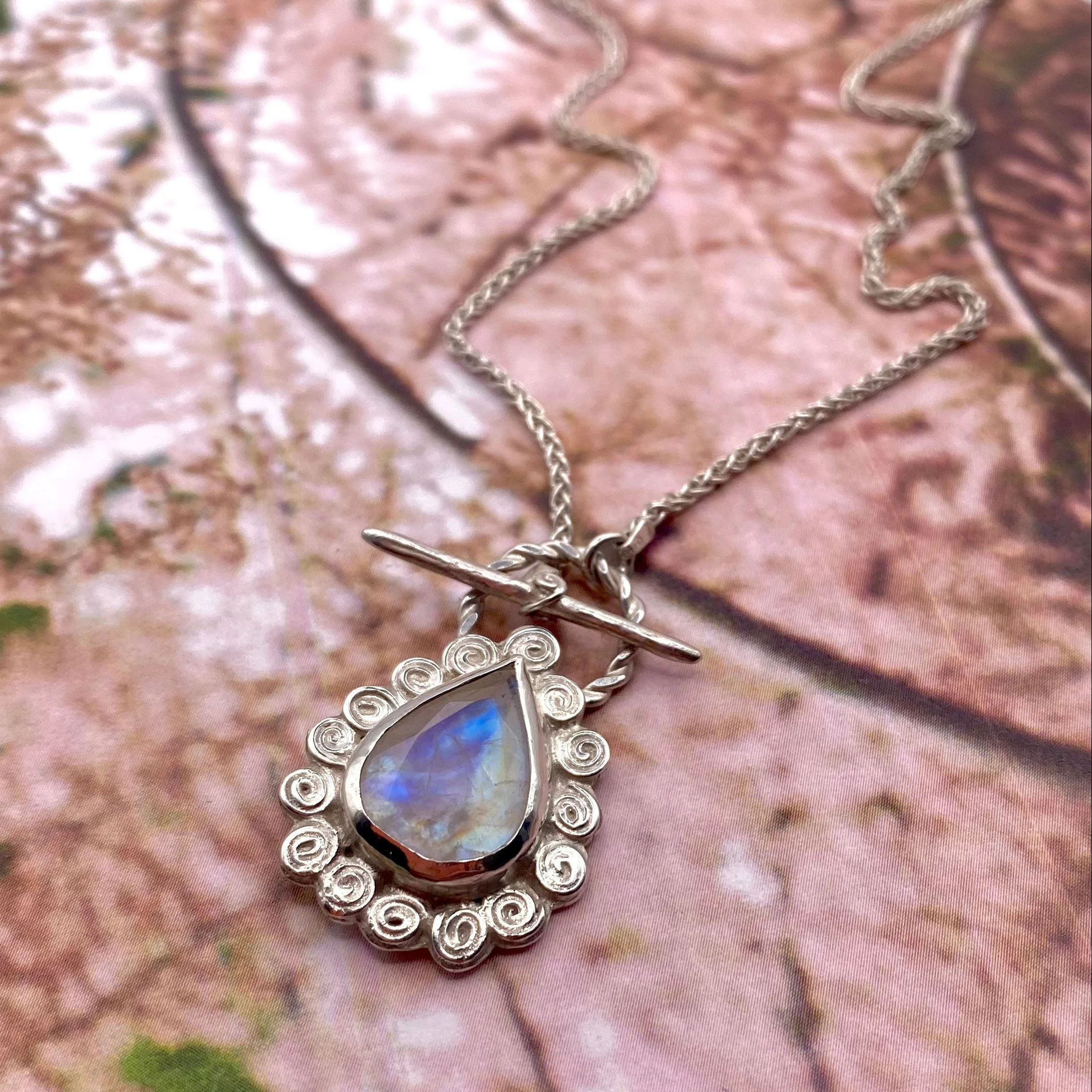 Large Pear Rainbow Moonstone Swirly Halo Pendant on pink crop.jpg