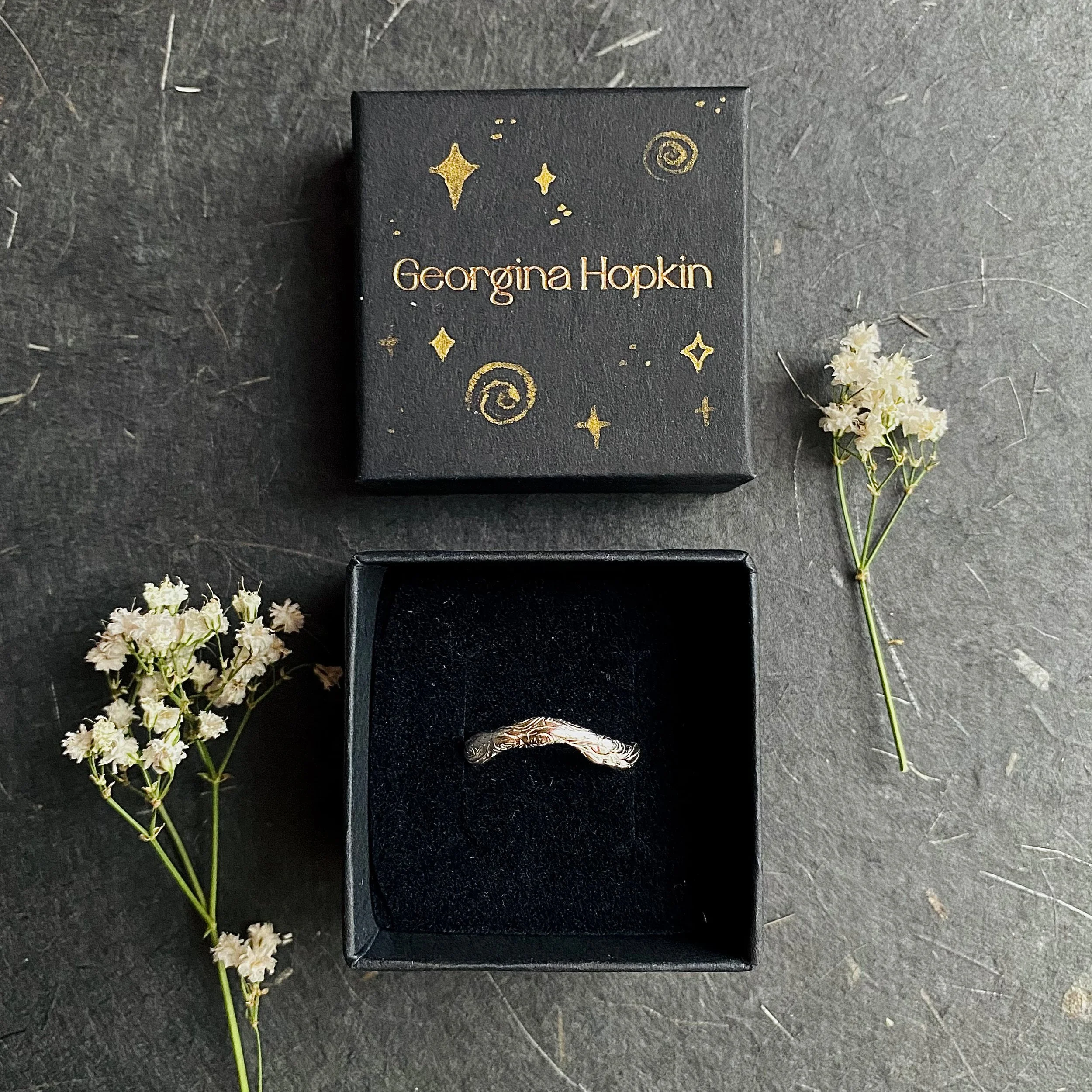 Silver curved carved ring in black painted box