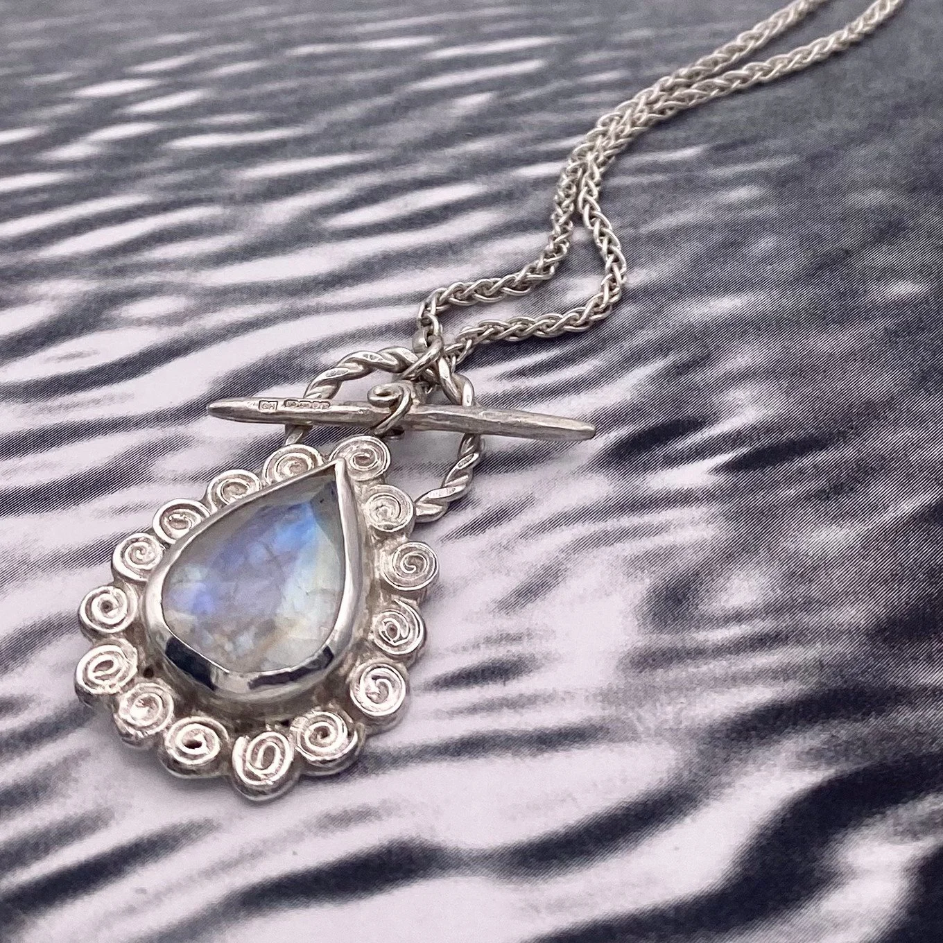 Large Pear Rainbow Moonstone Swirly Halo Pendant on water crop.jpg