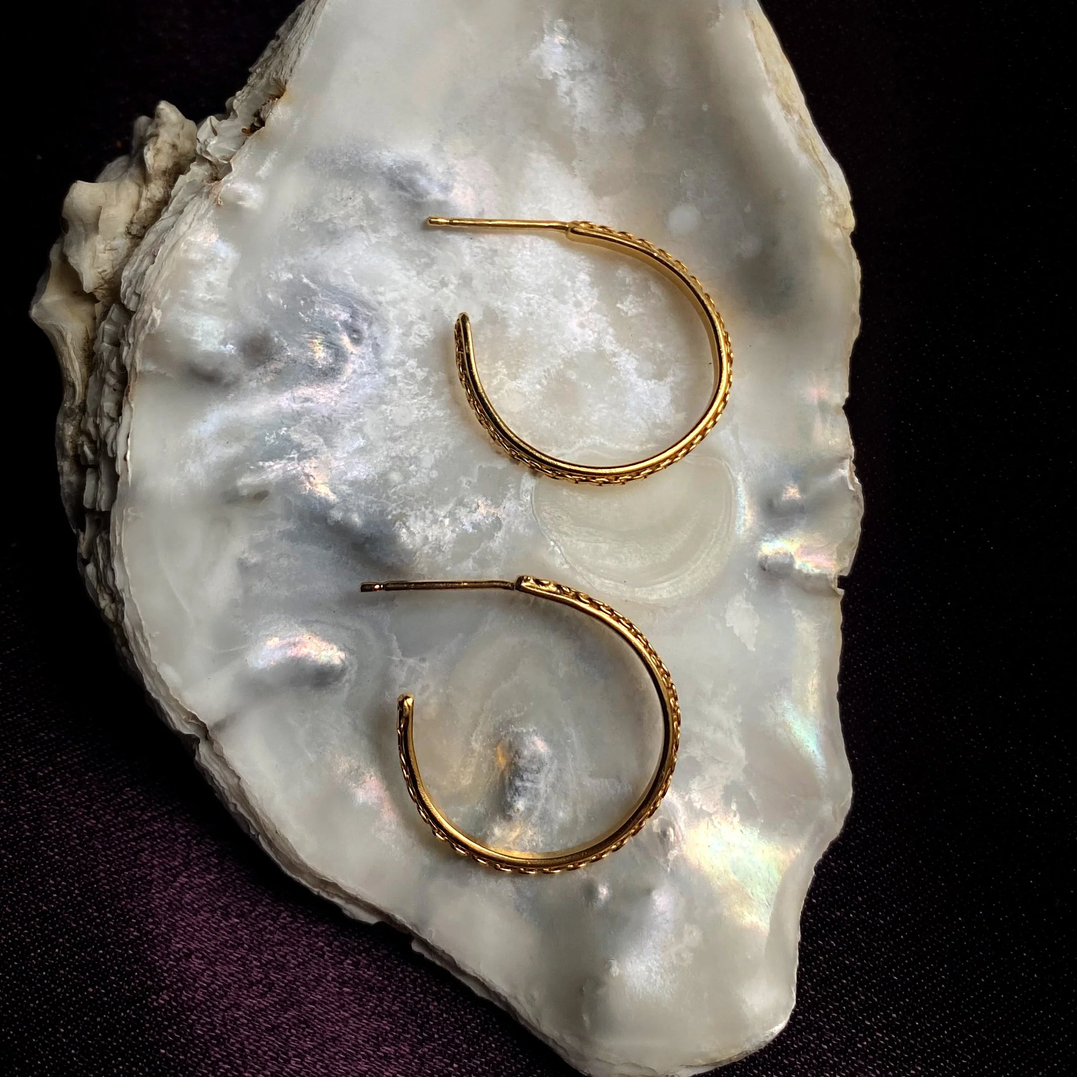 Gold plated chain hoops large on shell flat crop.jpg
