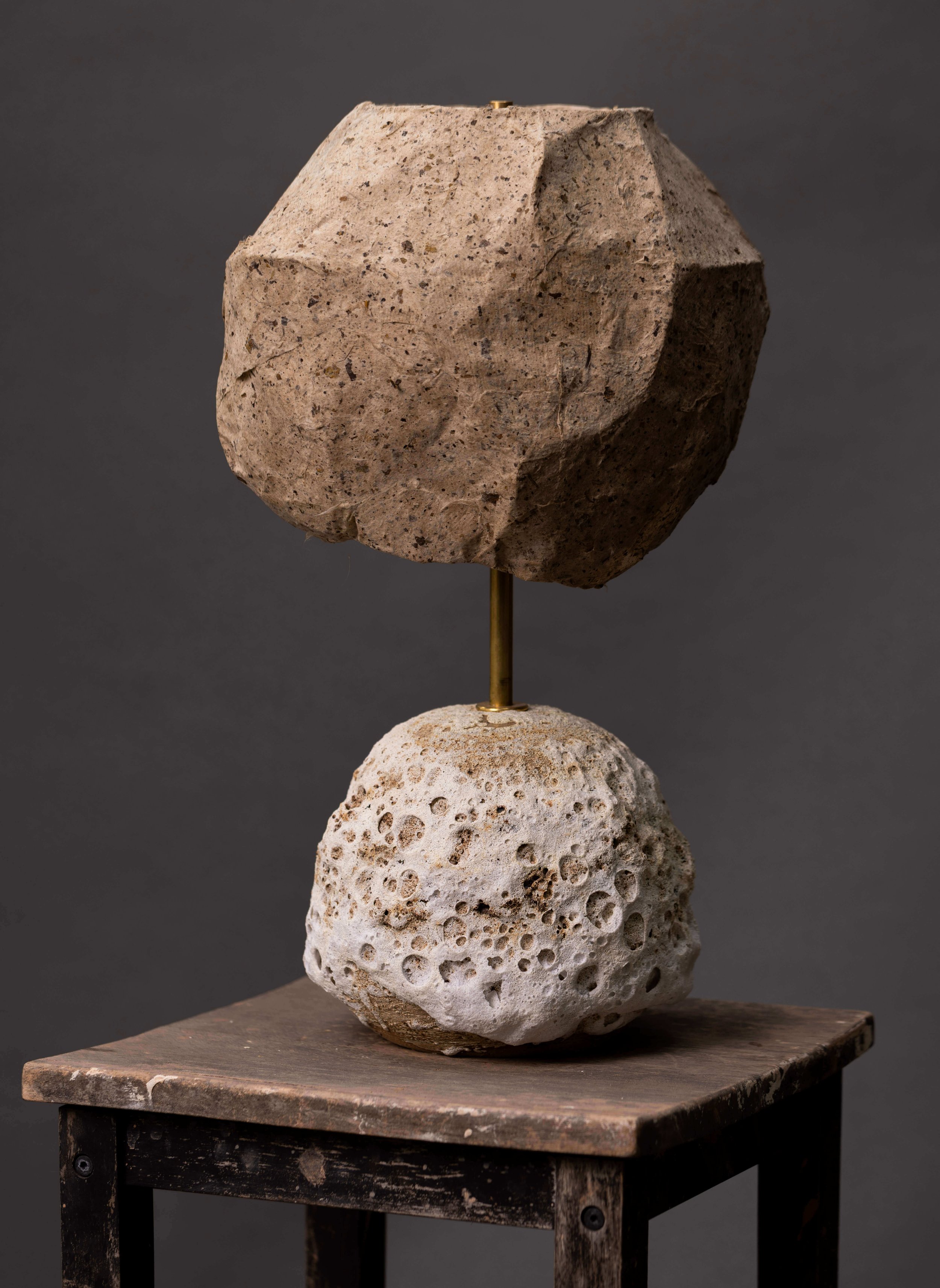 Sculptural lamp: crater-glazed round base, angular faceted shade, wooden stool