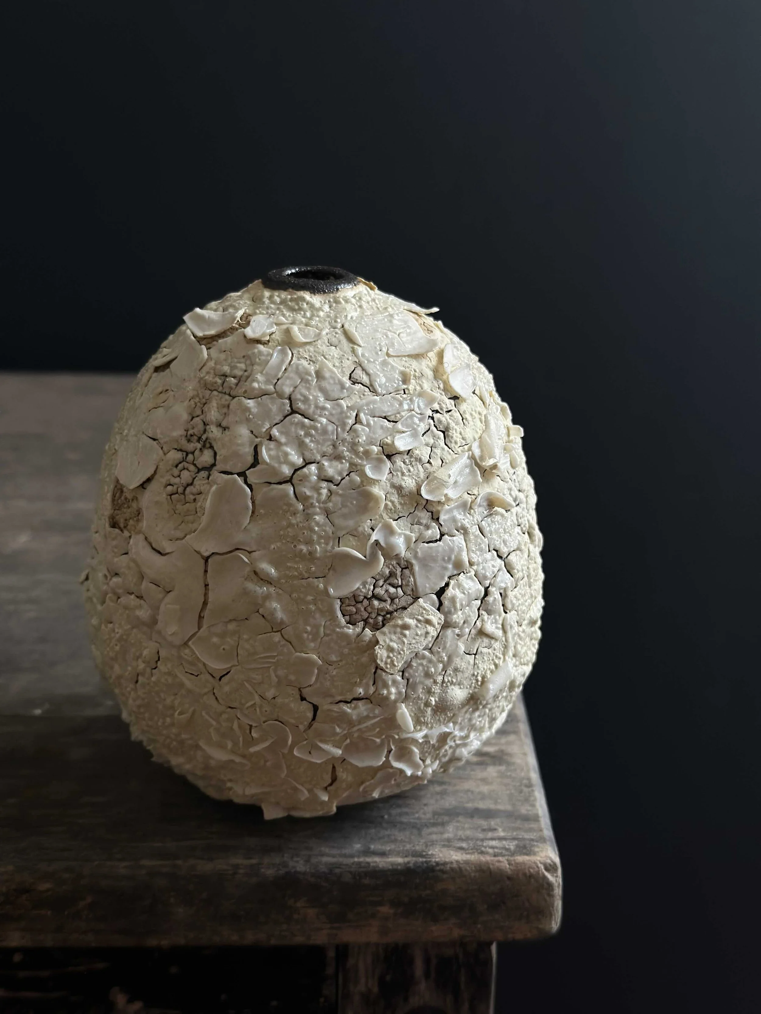 Tall egg-shaped vessel with dramatic white crawl glaze, large flaking plates