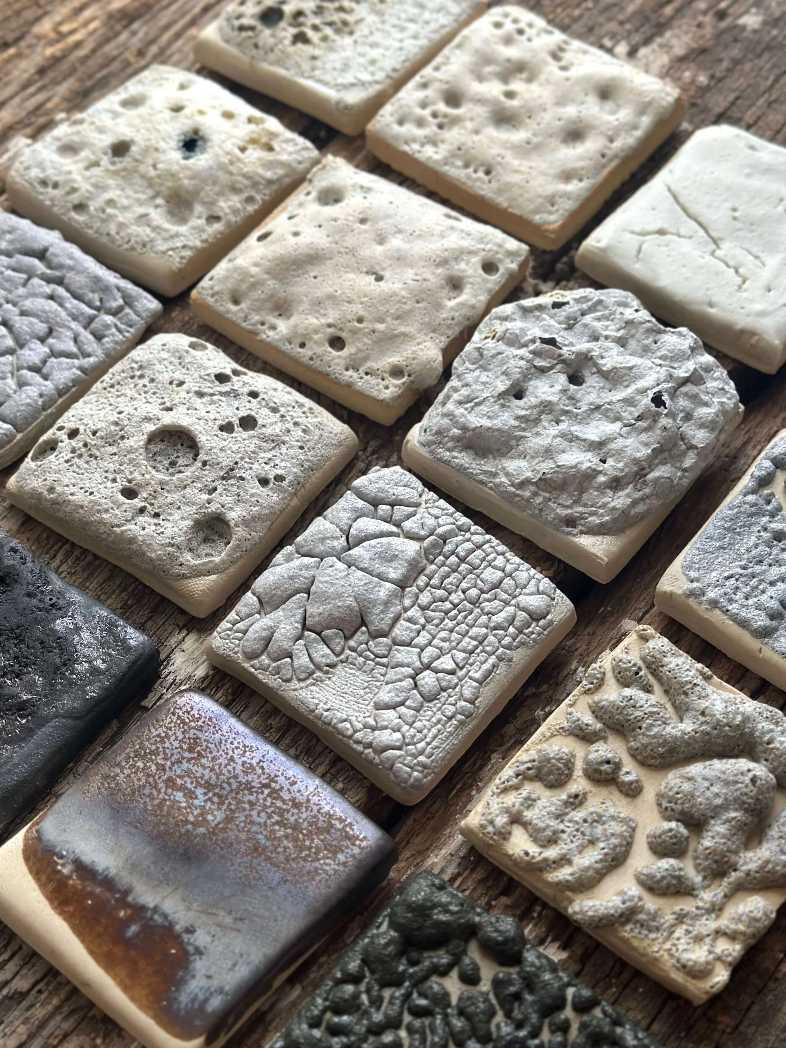 A collection of ceramic test tiles with various textures.