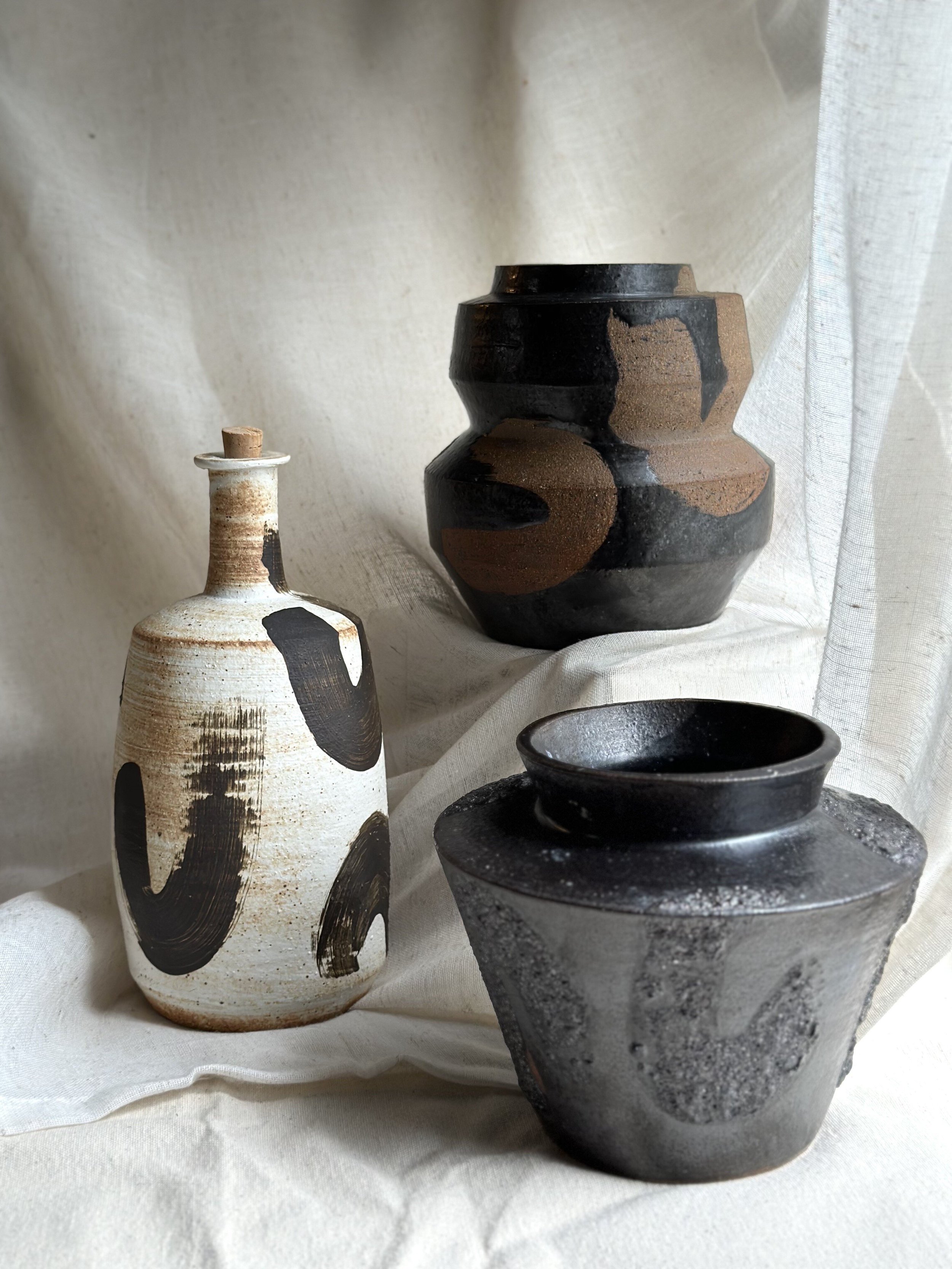 Triptych of Minimalist Vases: This captivating set contrasts stark black forms with raw ceramic textures, embodying the cycle from non-existence to life—a profound addition to collections that celebrate existential art and contemporary design
