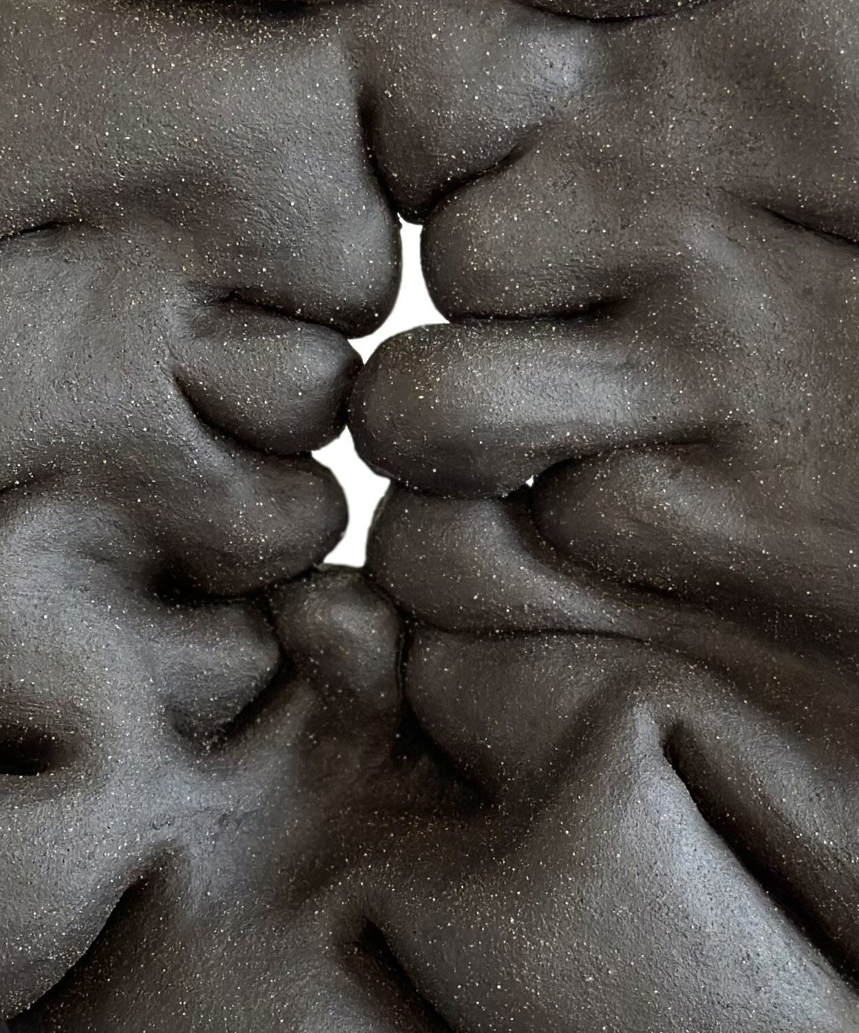 This artistic close-up captures the 'Unnamed Wormhole' ceramic sculpture's intricate folds, where the profound black texture symbolizes the enigmatic passages of cosmic wormholes, ideal for collectors and admirers of cosmic art