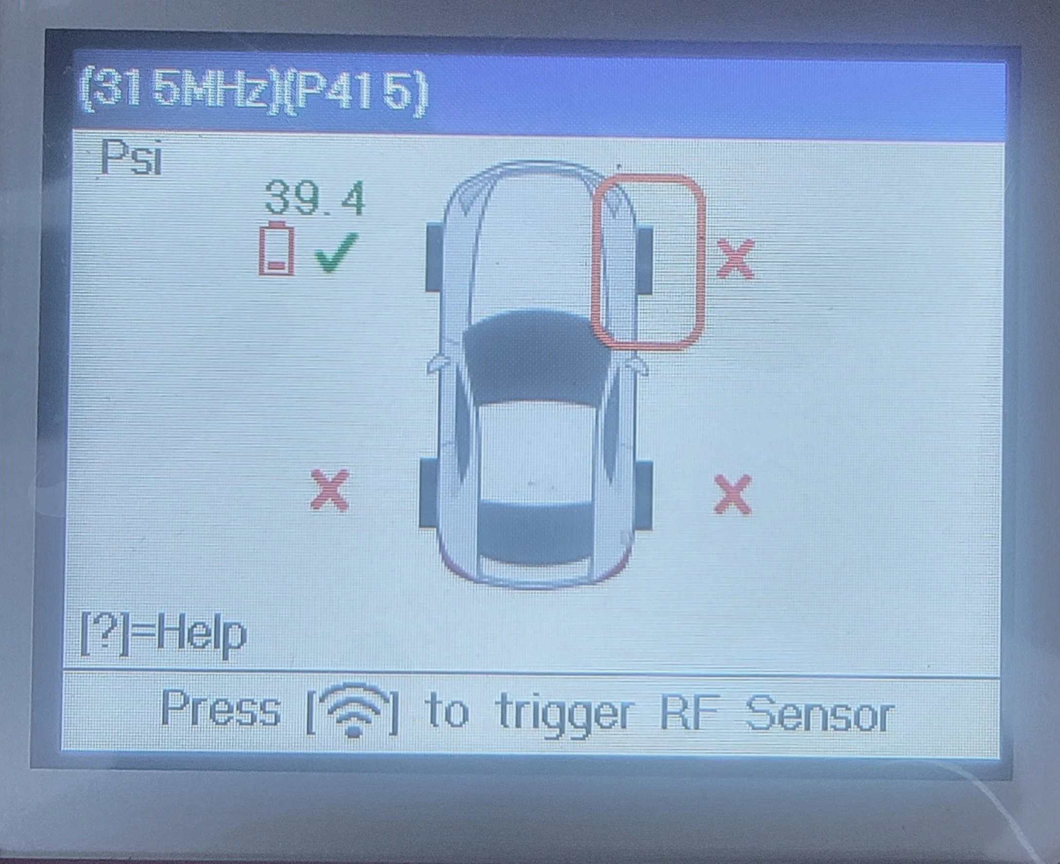 A car alignment screen showing a top-down diagram of a vehicle with red X marks on the front and rear wheels and a green check mark indicating proper alignment. The display shows 39.4 PSI pressure, with instructions to trigger an RF sensor.