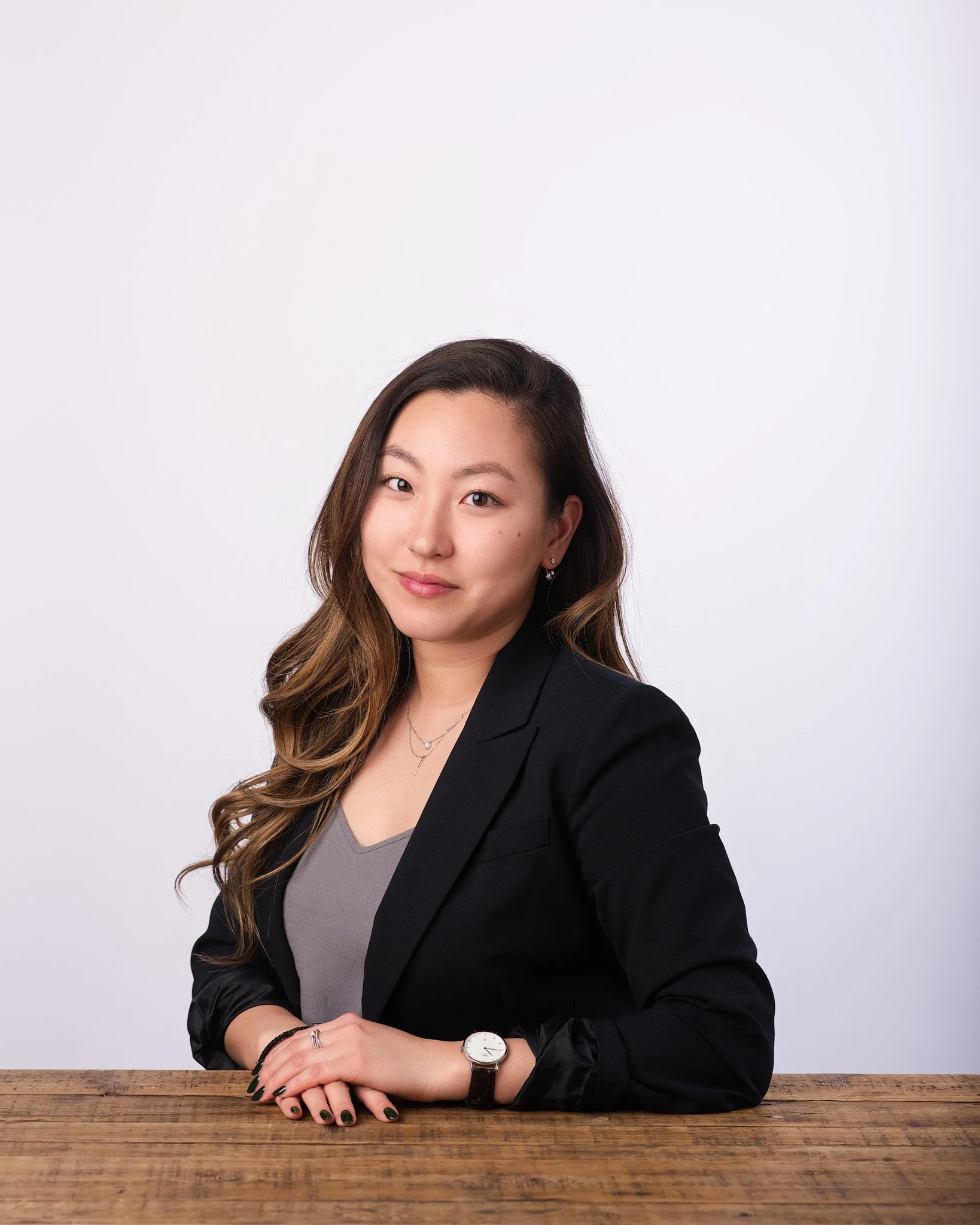 nyc headshot photographer portrait of a woman in a black blazer with soft lighting and a neutral studio background