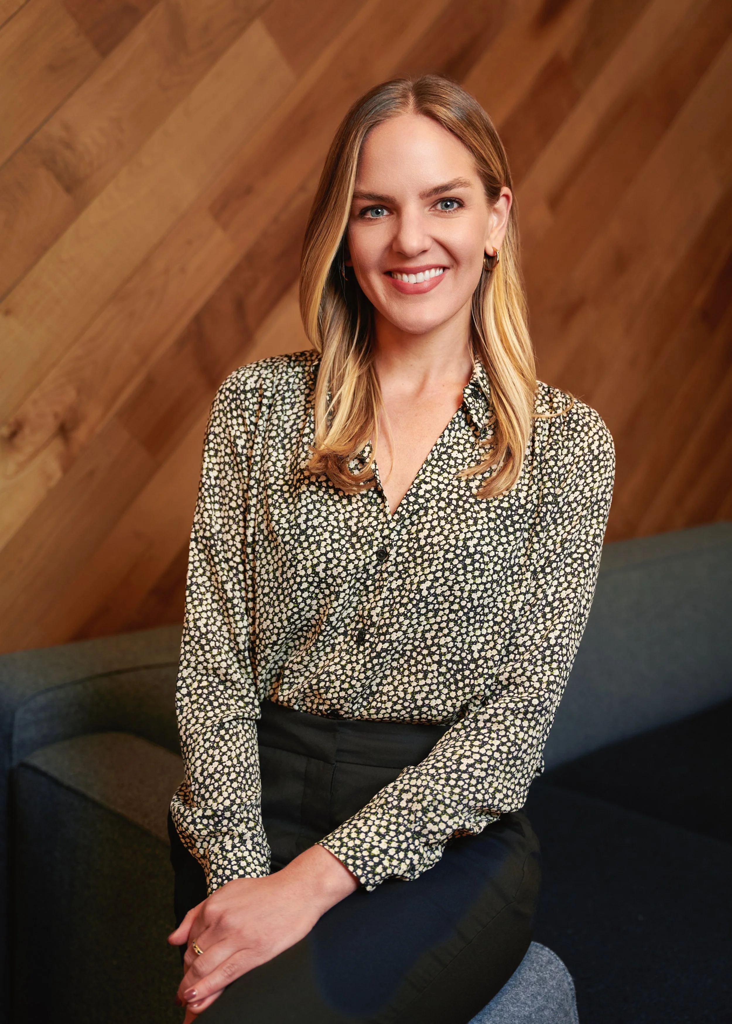Corporate lifestyle portrait of a woman seated in a modern New York City office interior
