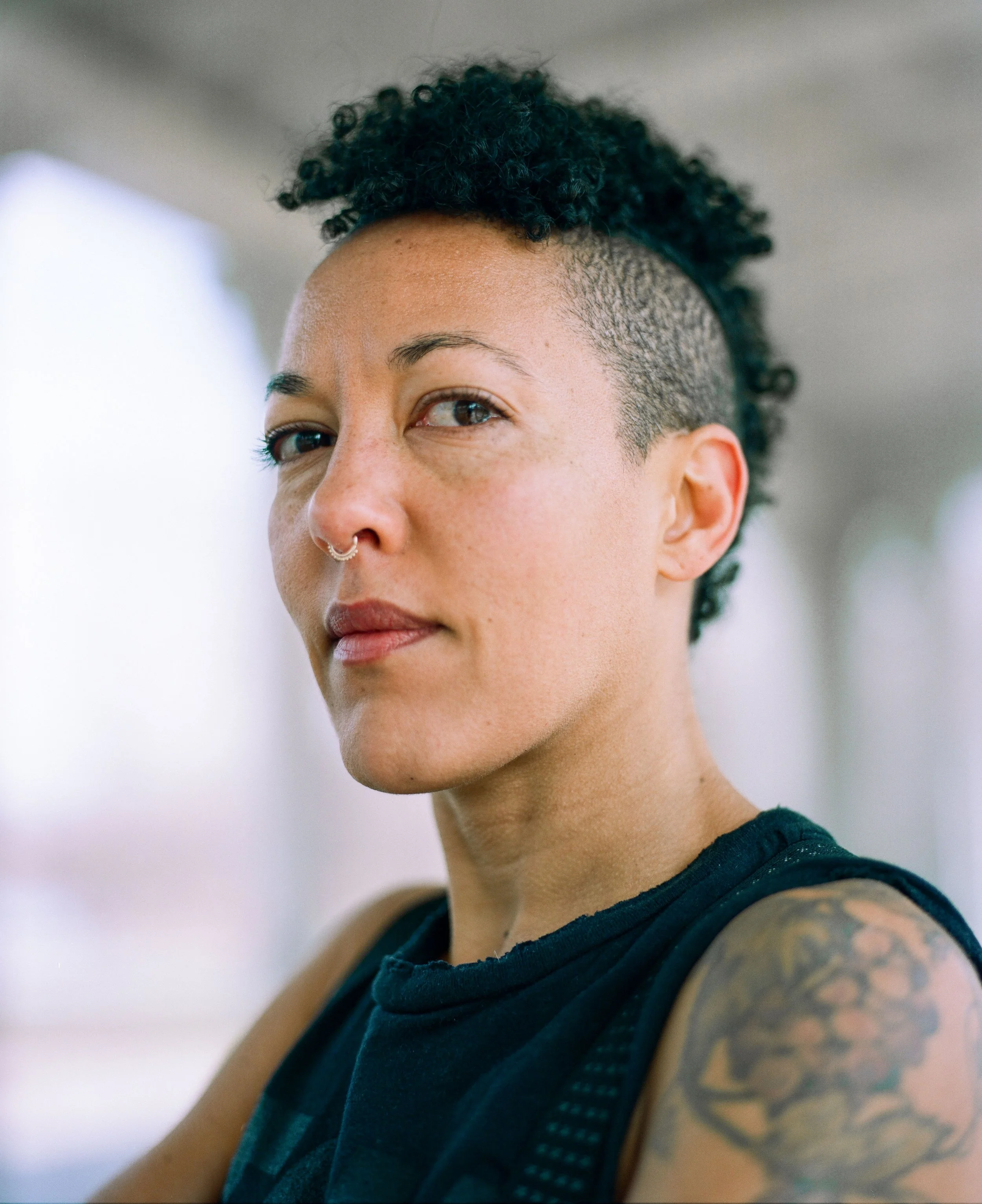 Creative portrait of a woman in Brooklyn, shallow depth of field, natural light, contemporary headshot style with soft background blur.