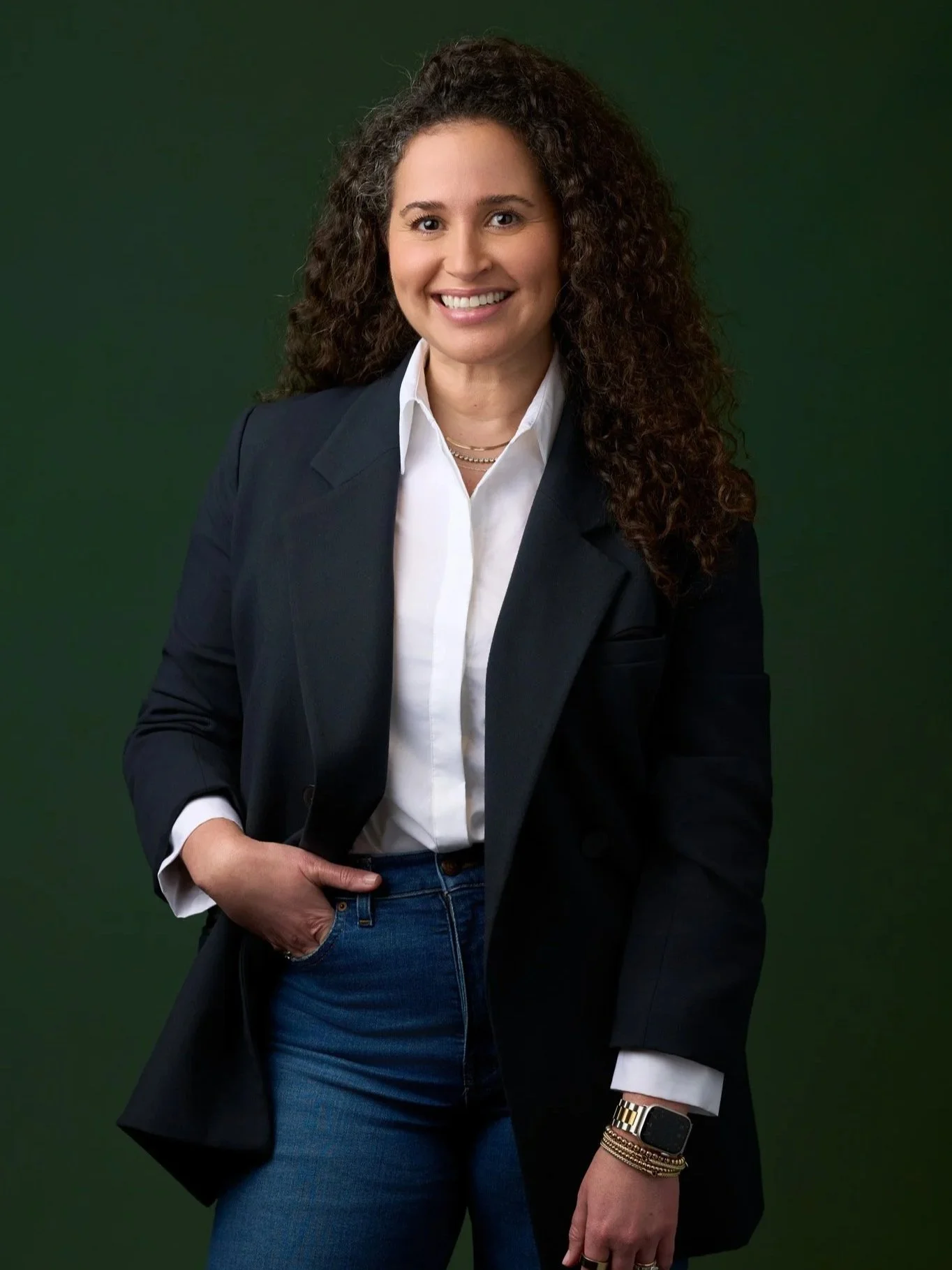 Studio headshot of a woman wearing a blazer photographed against a green background in New York City