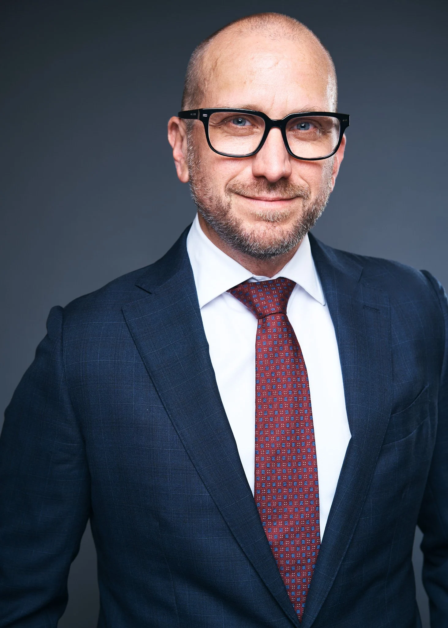 Professional headshot of a suited executive in New York, photographed by David Pexton Photography, clean studio lighting, NYC headshot photographer style