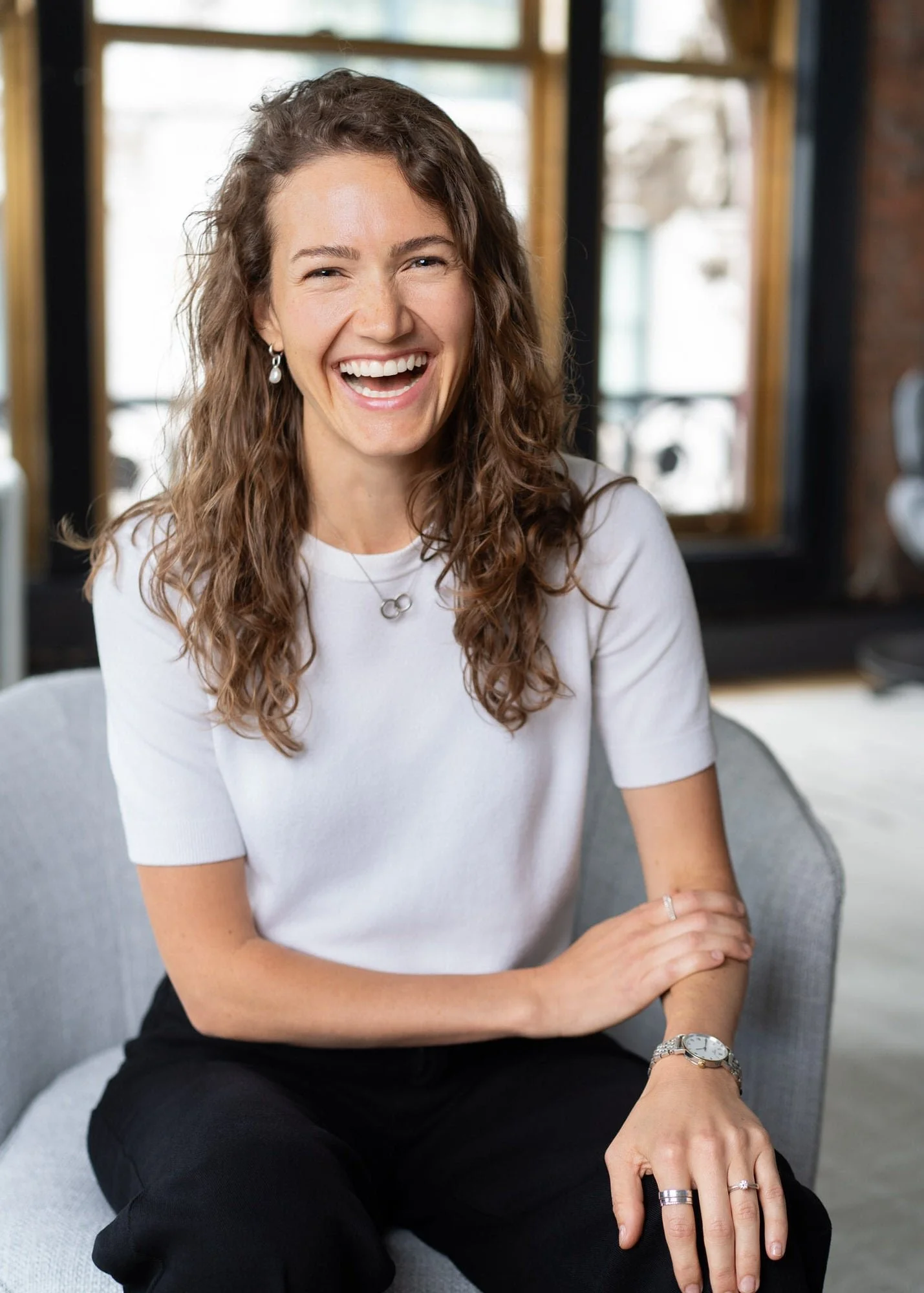 Female investment firm professional headshot with natural light, relaxed expression, photographed on location in New York City