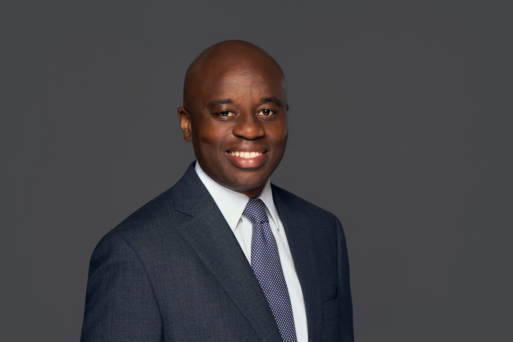 corporate_executive_headshot_gray_background_confident_smile_nyc_david_pexton_photography.jpg