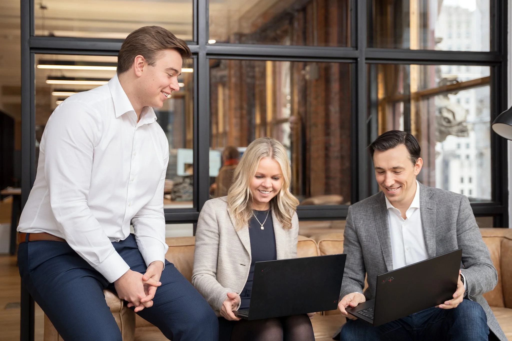 A corporate lifestyle shoot of a small team collaborating with laptops in a New York City office.