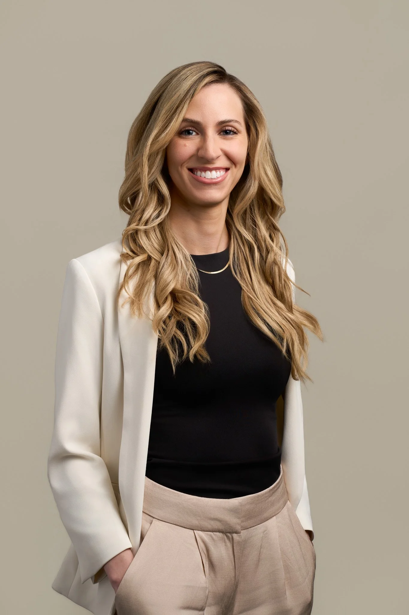 Blonde businesswoman in a cream blazer and black top, professional studio portrait photographed in New York City by David Pexton