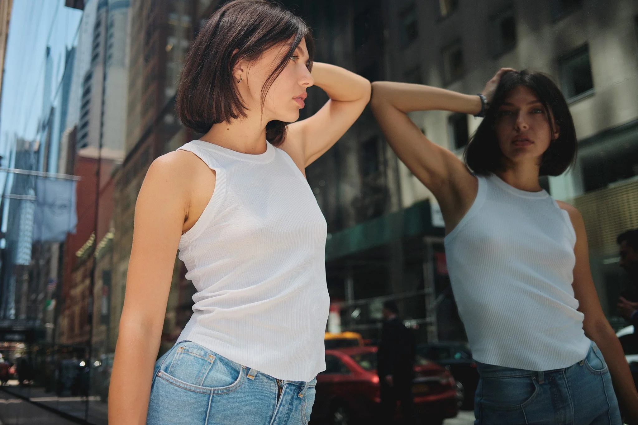 Personal branding photoshoot - Daria Shevchenko - in white tank top and jeans looking at her reflection