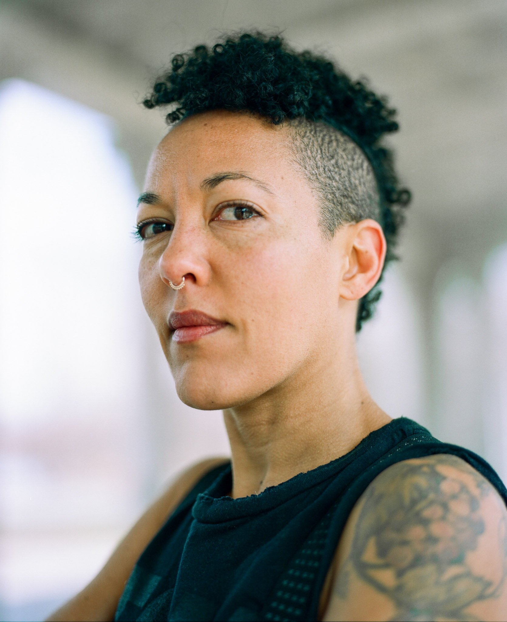 Creative medium format film portrait of a woman in Brooklyn, shallow depth of field, natural light, contemporary headshot style with soft background blur.