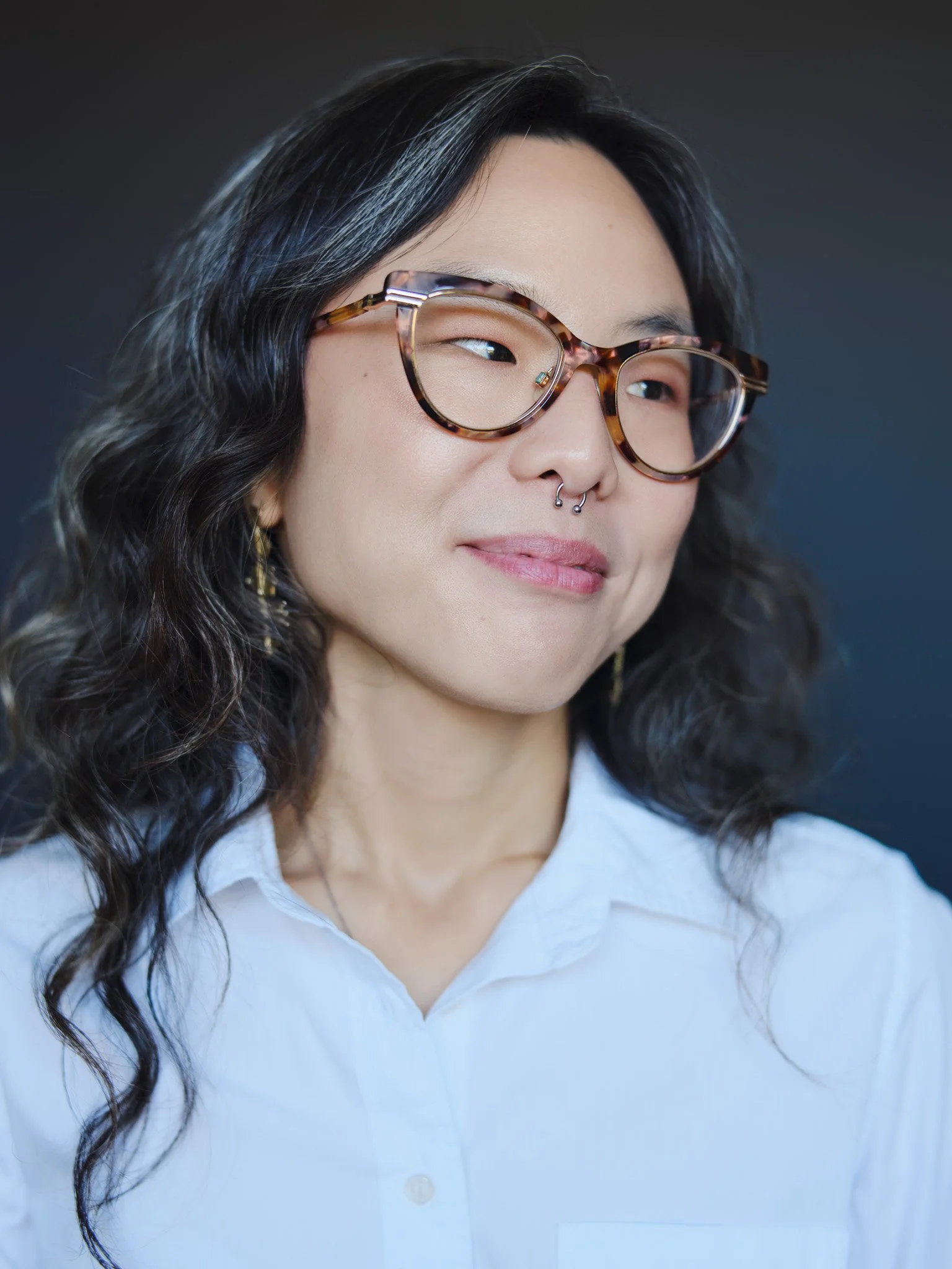 Color actor headshot of an asian woman wearing a white shirt and glasses, photographed in soft natural light with a calm, confident expression, Brooklyn NYC, by David Pexton Photography