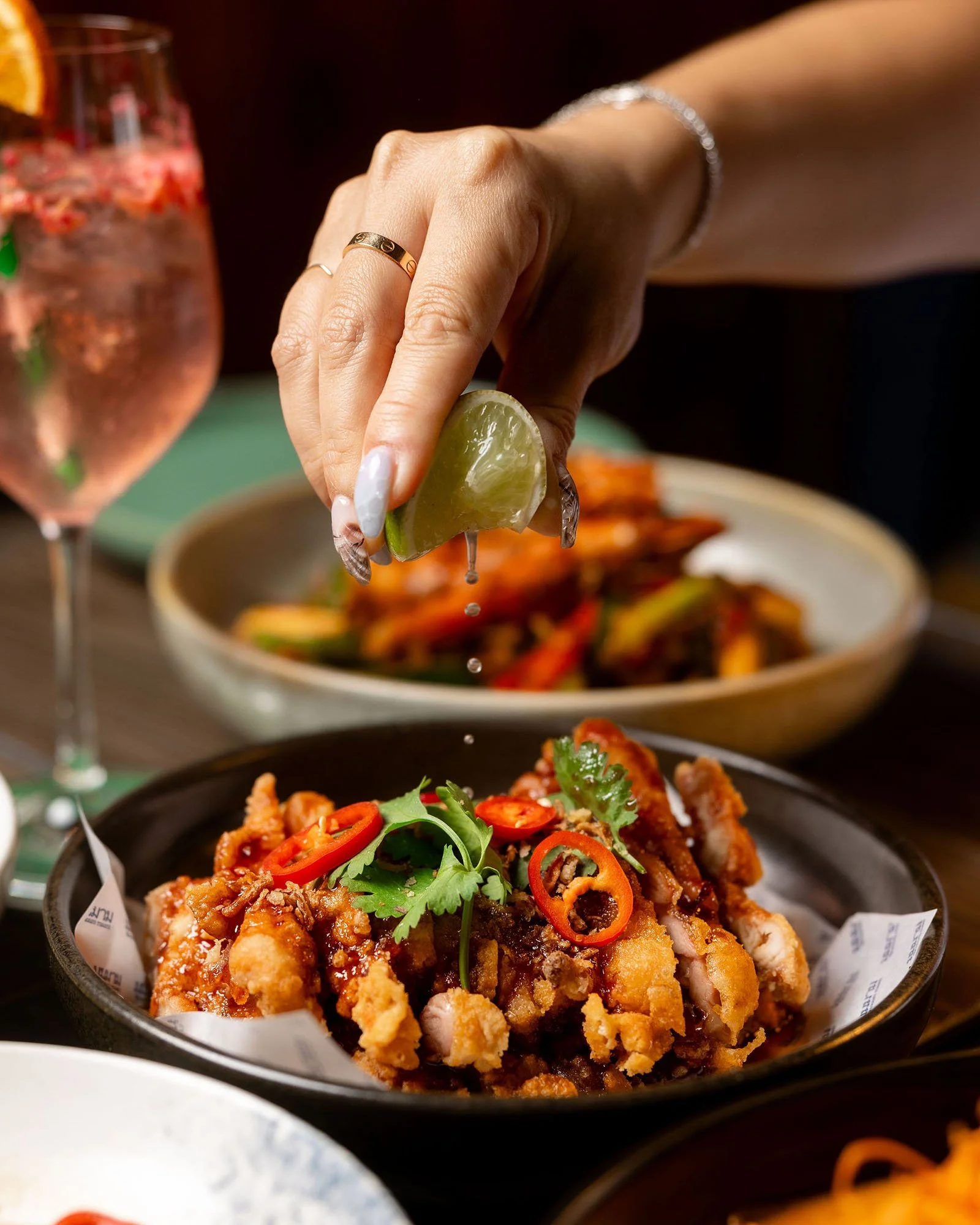 Crispy skin chicken with fresh lime being squeezed over the top at Muum Maam.