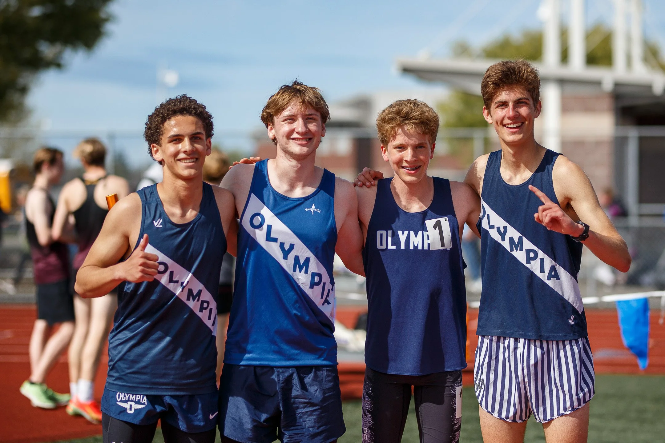 Quenton Lanese and Olympia Bears teammates celebrating after a relay at the Mt Tahoma Track Festival.