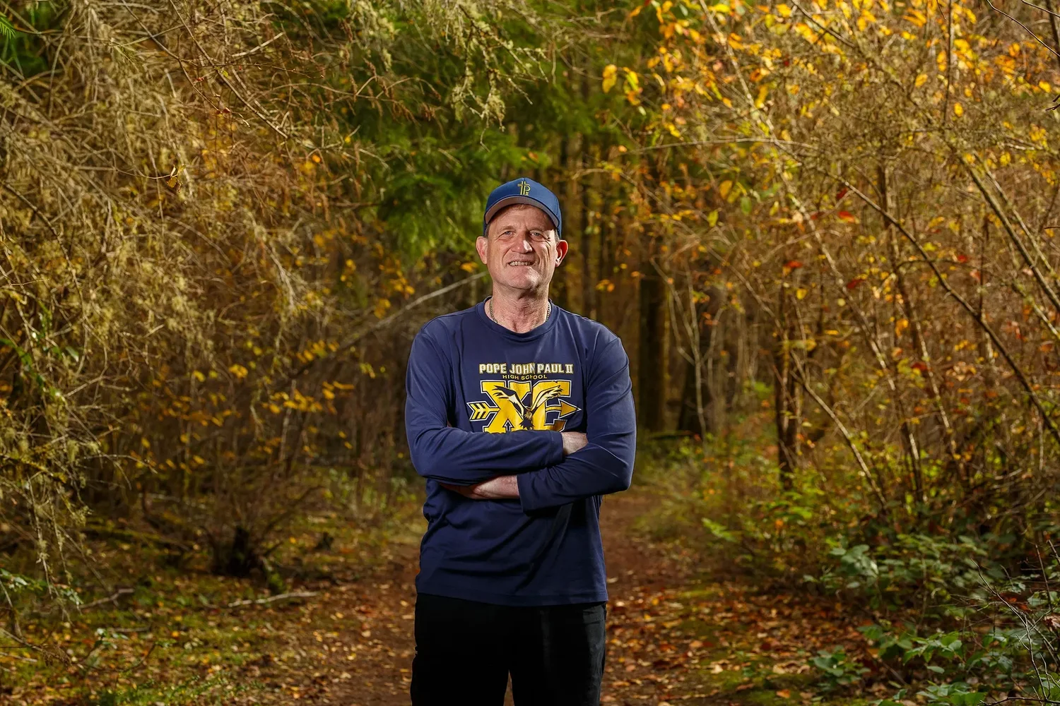 Coach Larry Weber photographed outdoors against autumn forest color for a hall of fame induction portrait