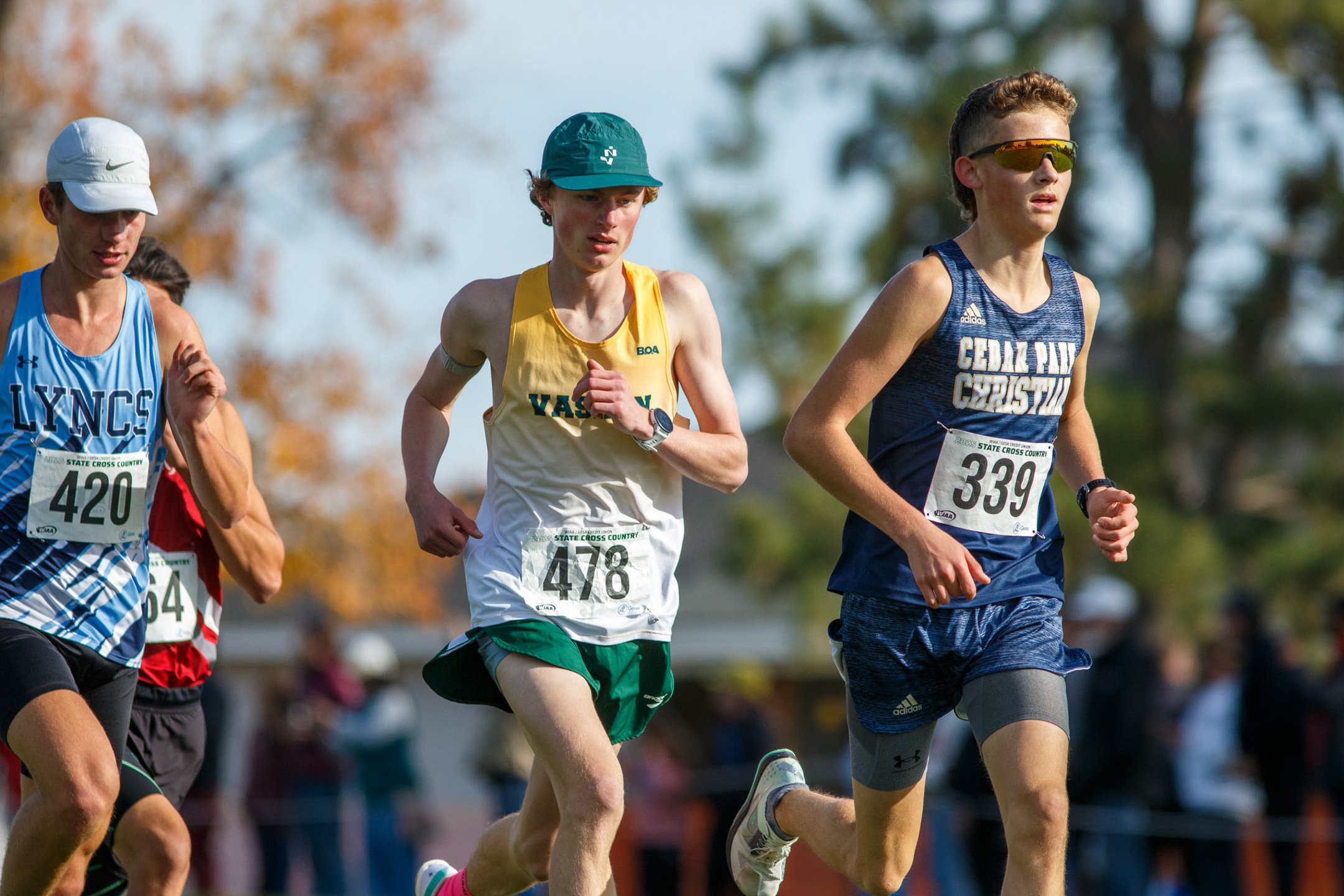 High school runner in a Vashon Island singlet racing at the state championships.