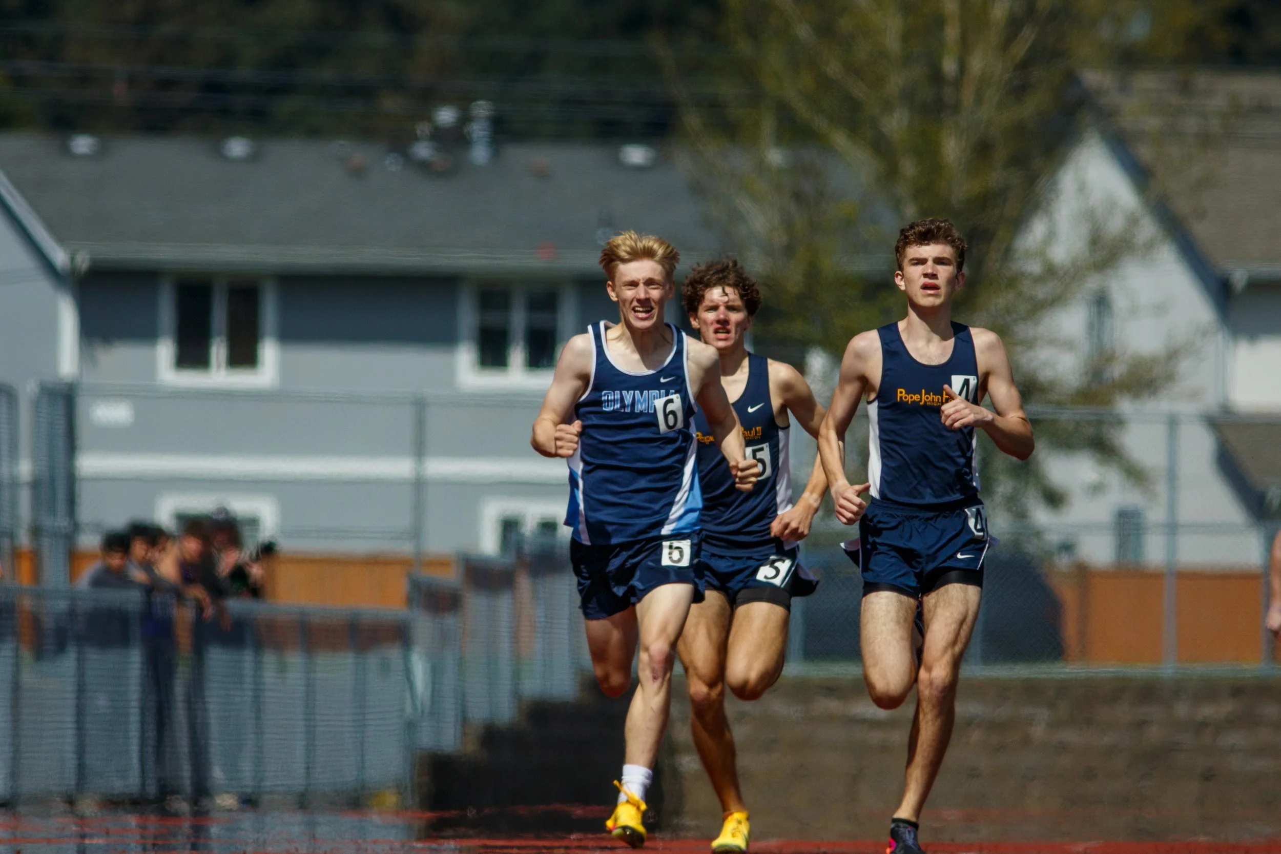 Bryce Byers of Olympia High School outkicking two Pope John Paul II runners during the 2026 Mt. Tahoma Track Festival.