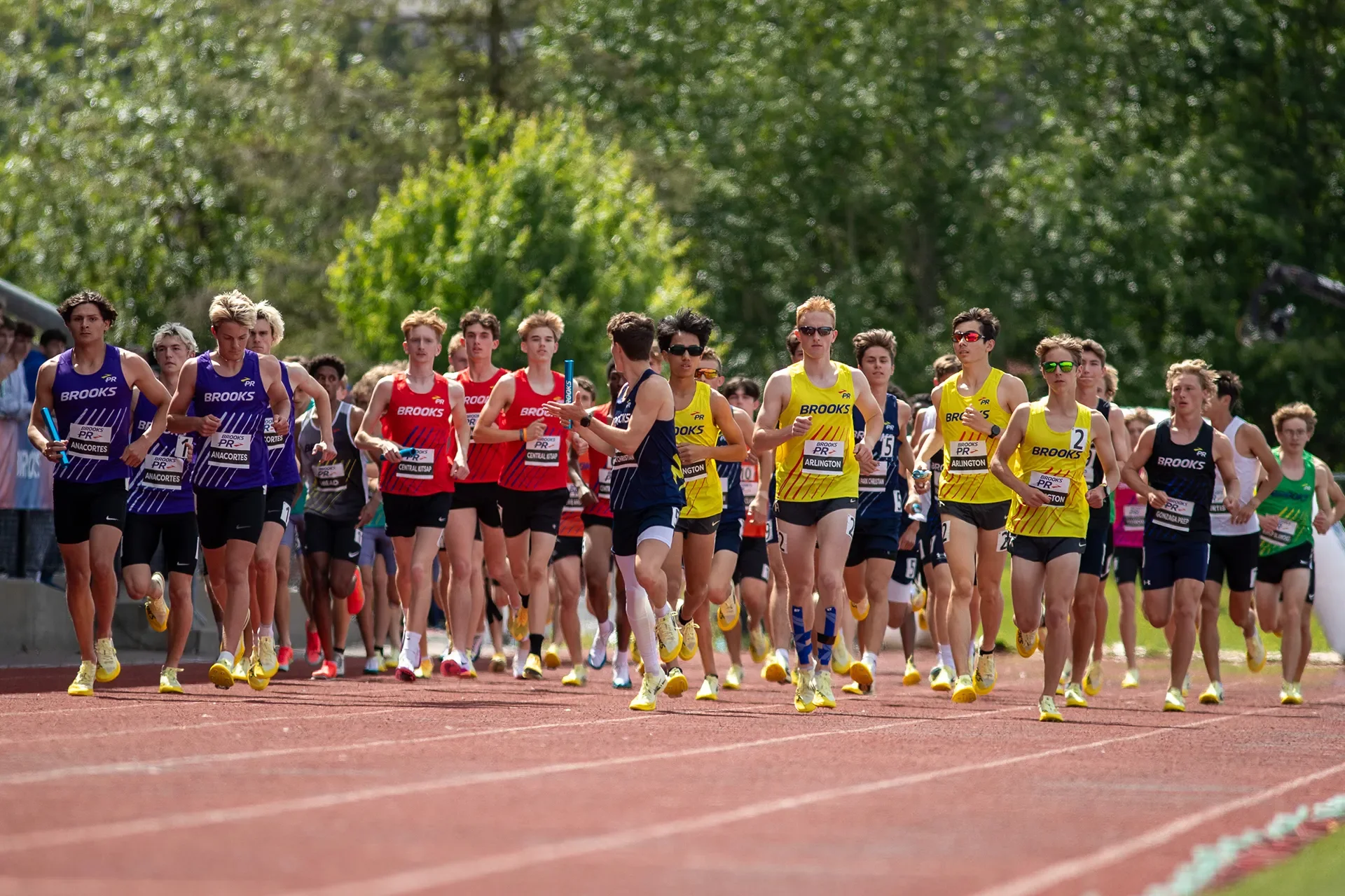 A wide, dynamic shot of the distance running athletes entering the tracking before the highly competitive Washington-only Boys 4x800m relay at the 2026 Brooks PR Invitational.