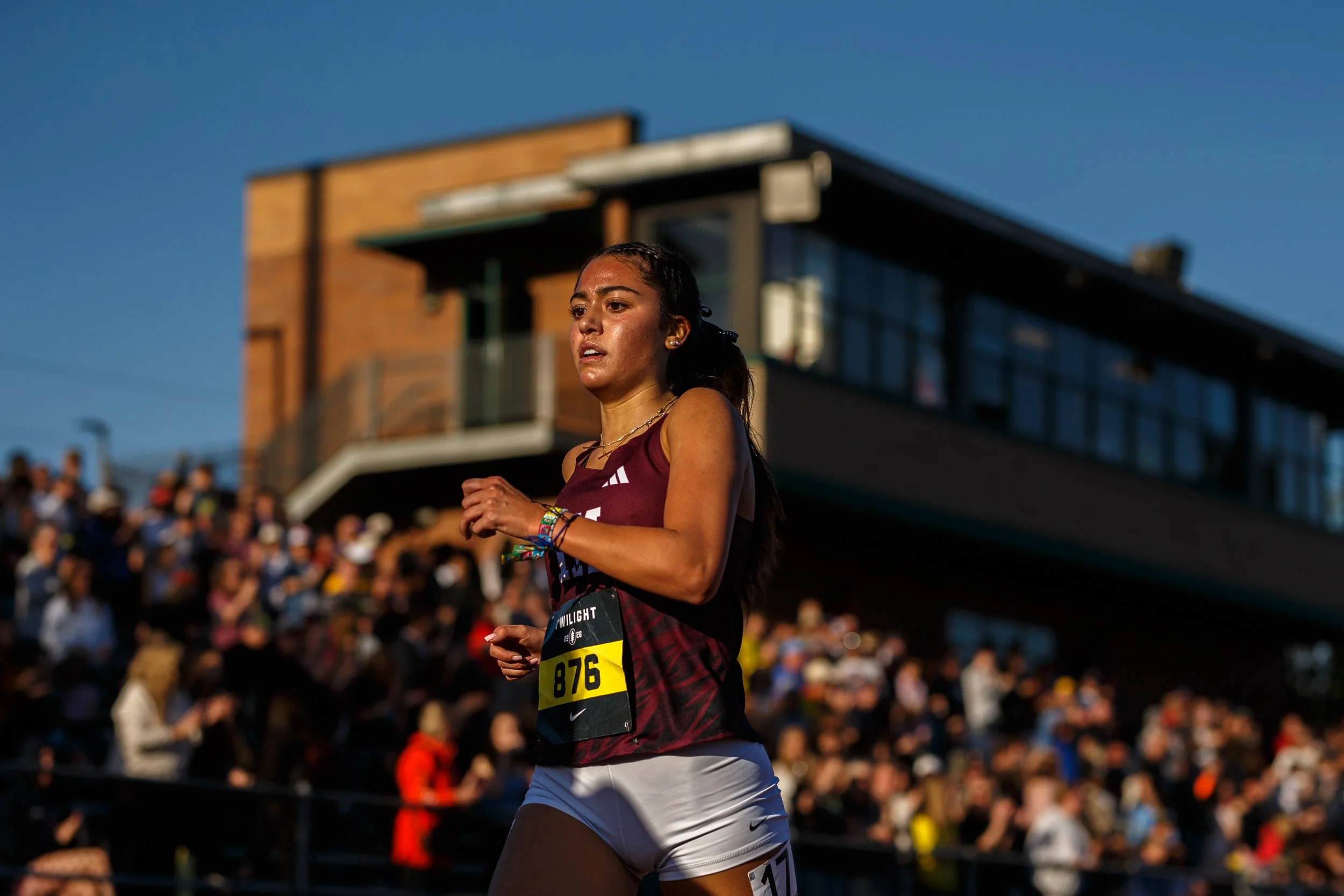 Mercer Island High School and Nike Elite runner Sophia Rodriguez illuminated against a blurred stadium crowd, featured in the elite 3200m preview for the 2026 South Sound Classic.