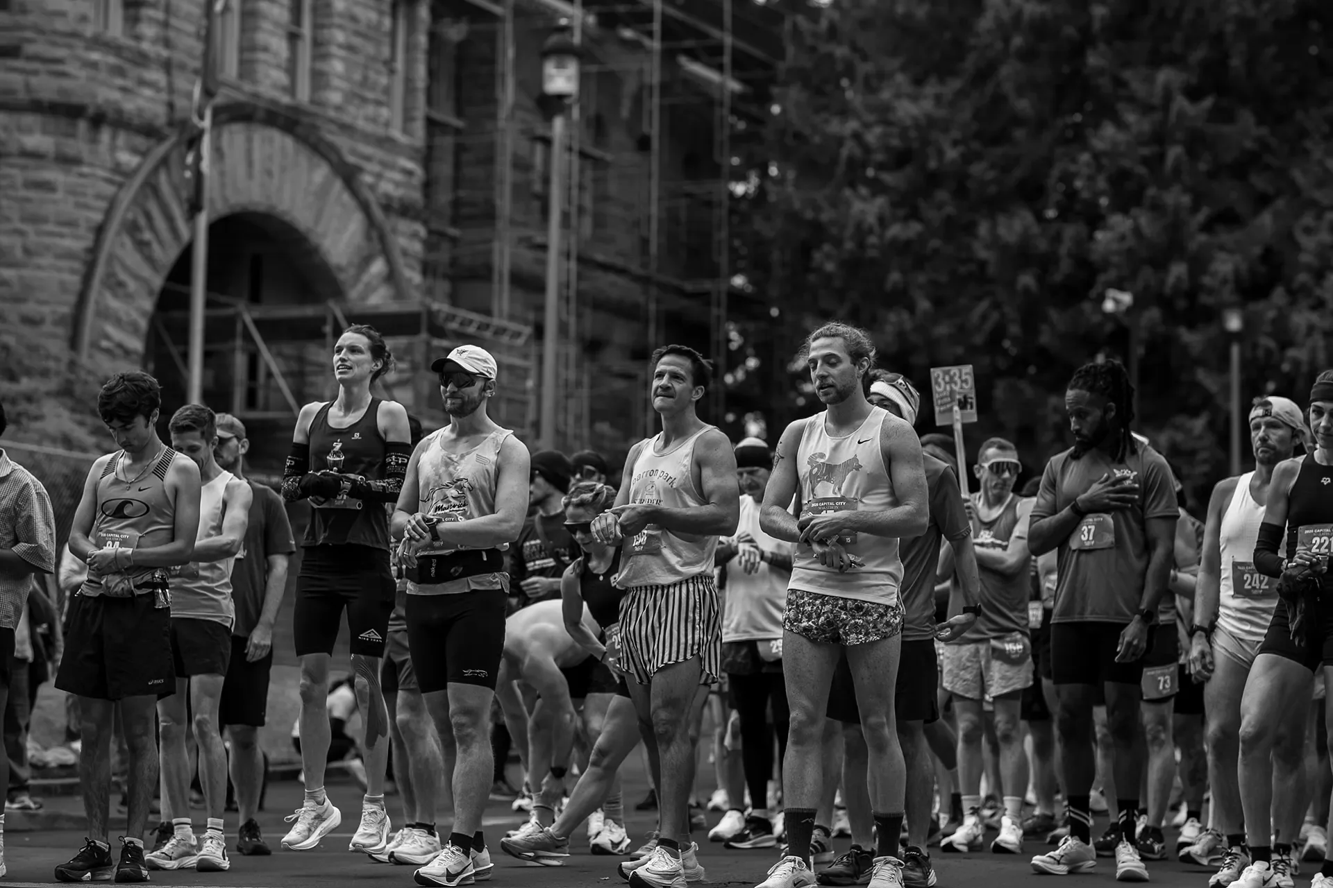 Black and white photo of runners including Jesse Stevick standing at the start line of the 2026 Capital City Marathon in Olympia.