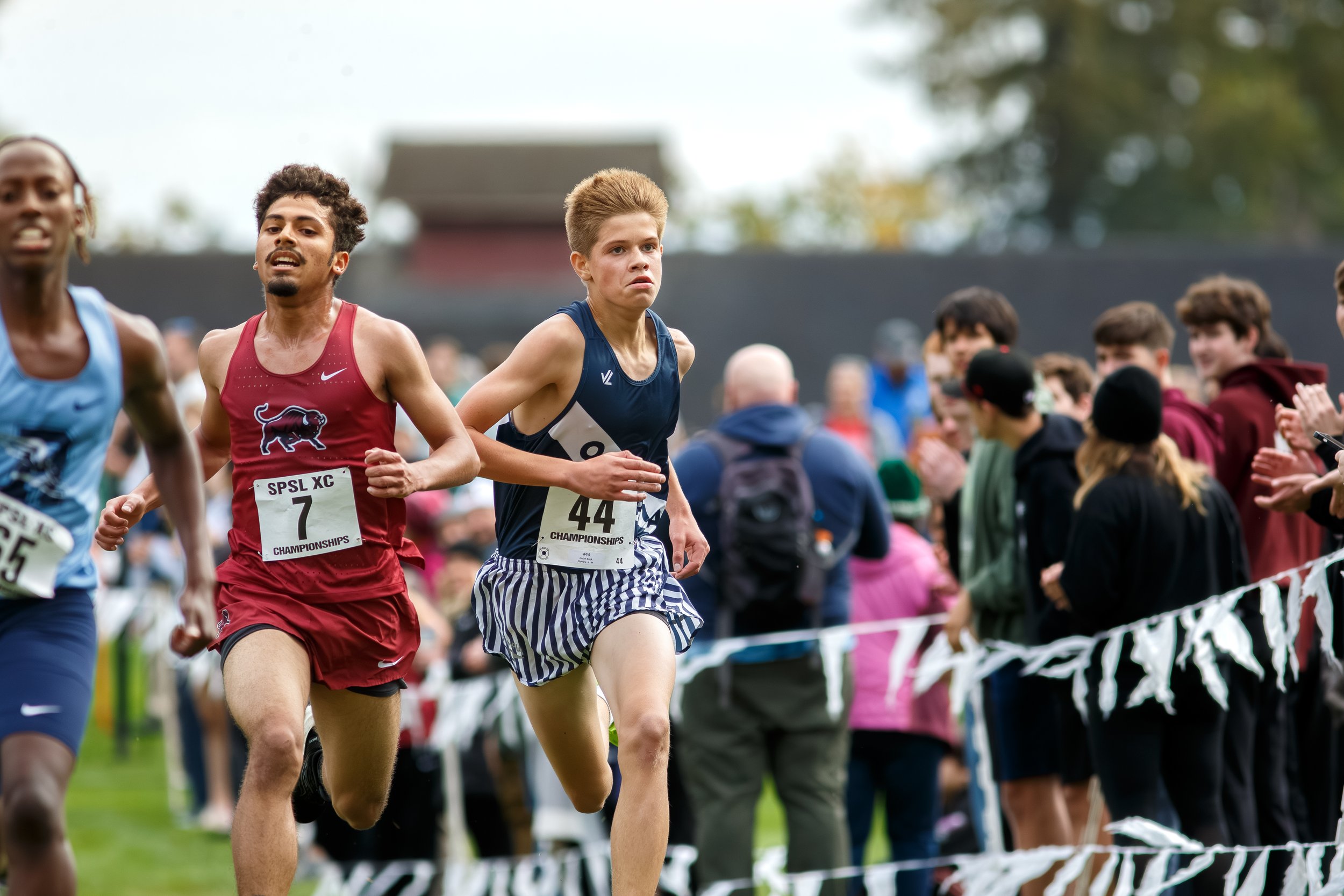 Judah Beck of Olympia High School finishing the varsity race at the 2025 SPSL 4A League Championships at Fort Steilacoom, running behind a competitor in a maroon uniform.