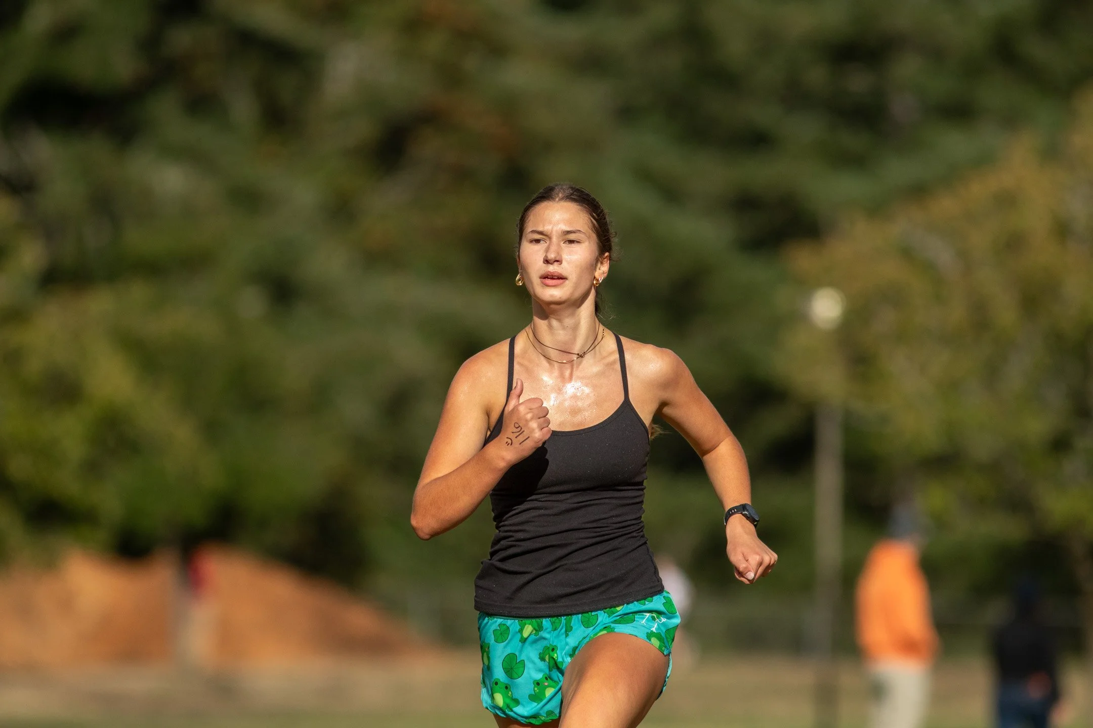 Carolina Schilter, wearing a black top and frog-print shorts, finishes the 2026 Olympia Time Trials.