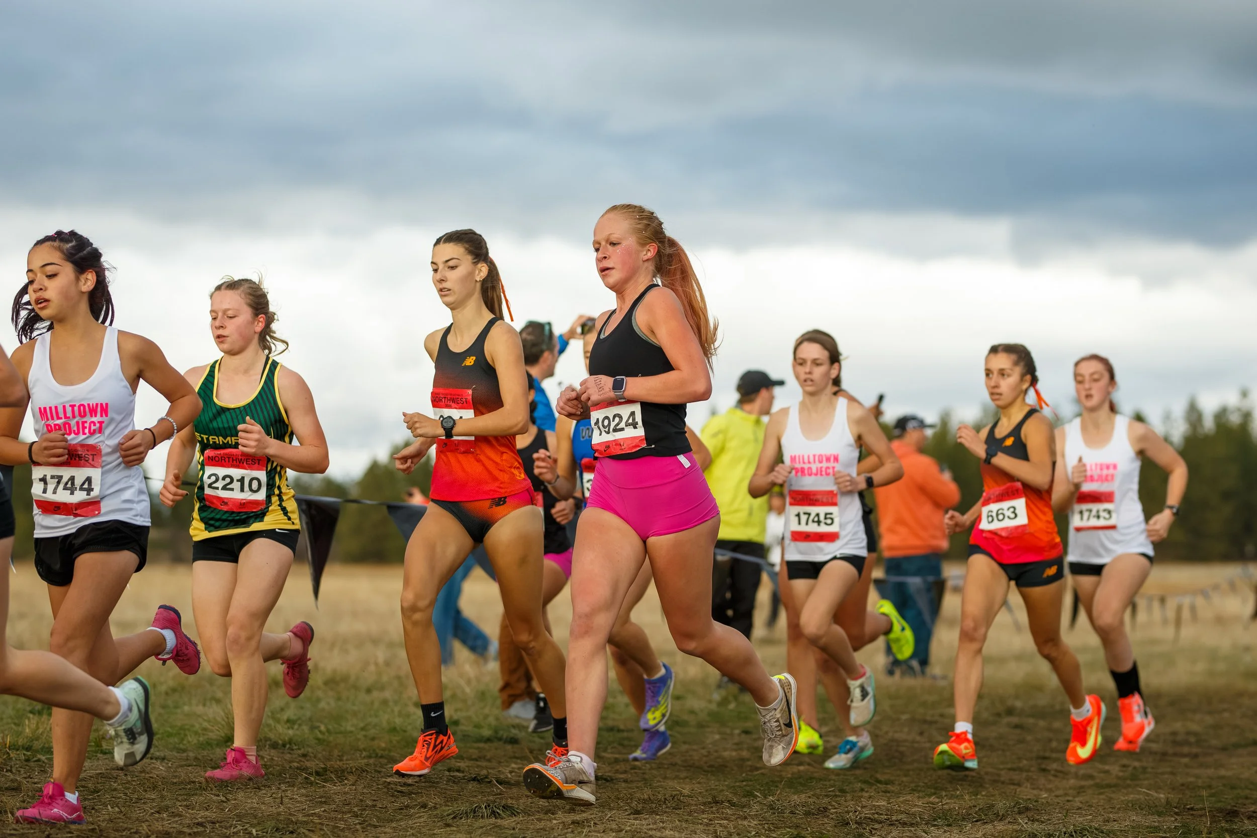 Azalea Barksdale of Olympia High School competing in a pack of runners at the 2025 NXR Northwest Championships in Spokane, Washington, wearing a black uniform.
