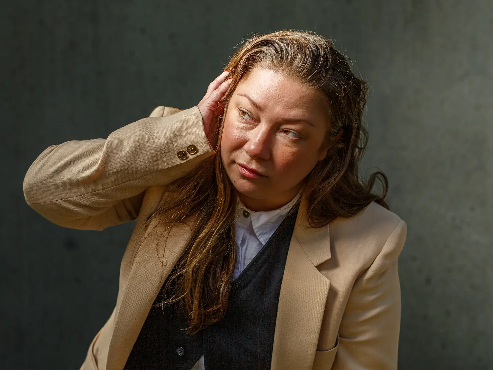 A high-voltage, cinematic commercial portrait of a professional woman against a textured concrete background. This 'Atmospheric Reality' capture by Russell Moore acts as a psychological conversion trigger for e-commerce and brand identities.