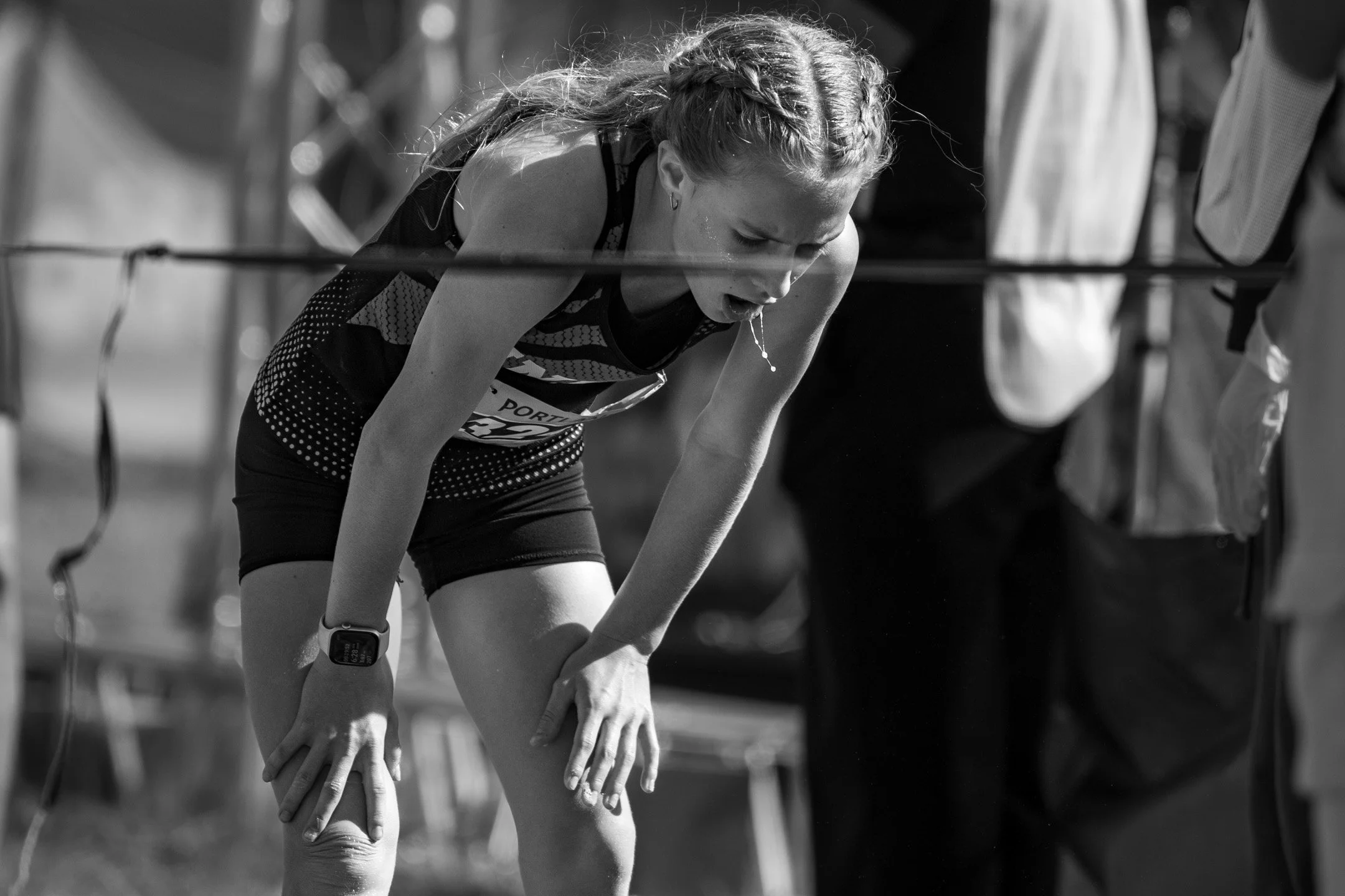 Black-and-white image of Union freshman Frances Armerding bent over with her hands on her knees, gasping after the finish.