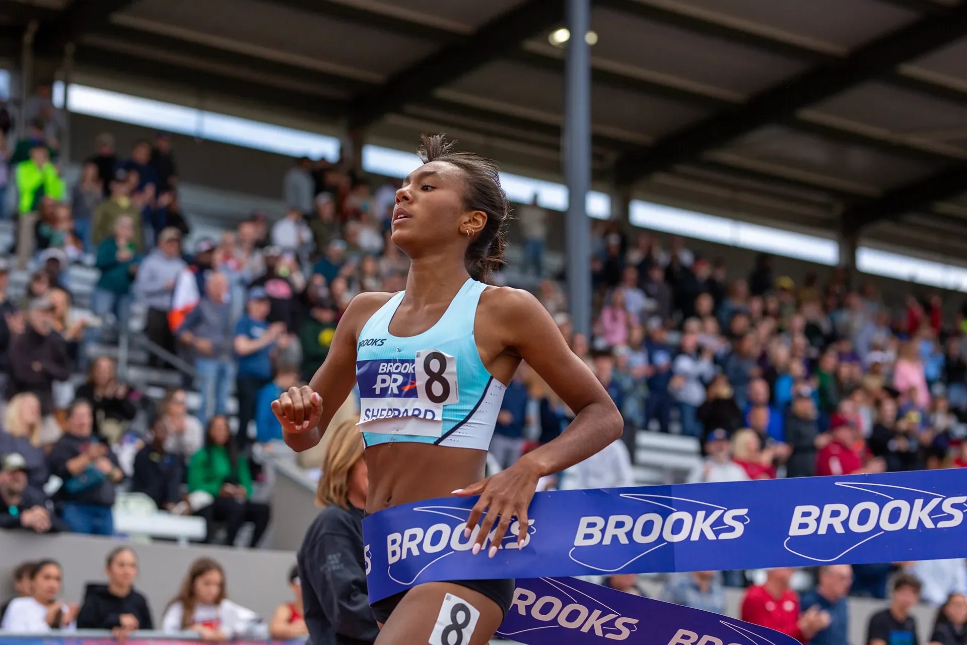Paige Sheppard executing a fierce sprint finish to break the tape and set a new meet record in the Girls 800 Meters at the 2026 Brooks PR Invitational in Renton, Washington.