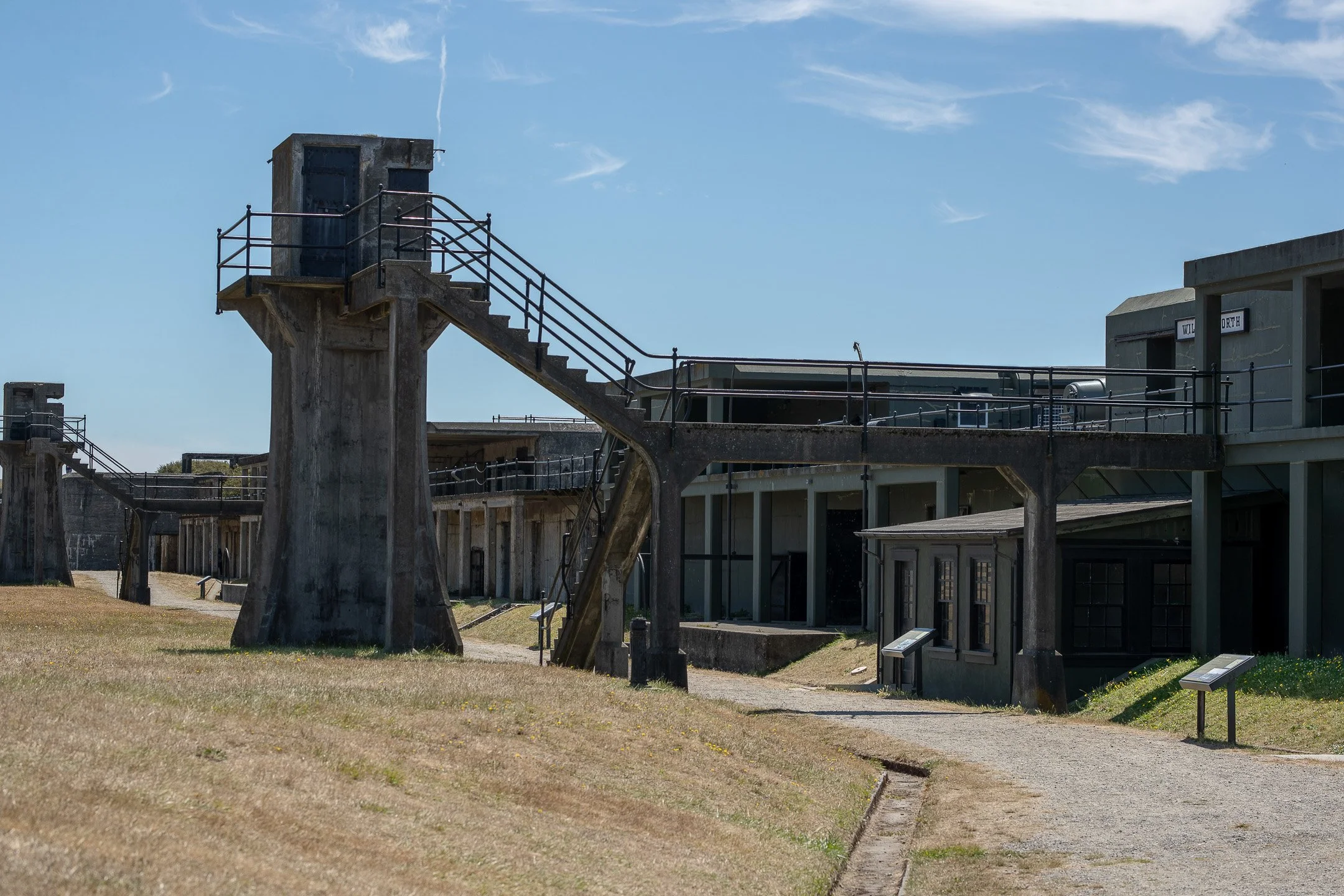 Historic military batteries and open grassy lawns at Fort Casey State Park on Whidbey Island under a clear blue sky.