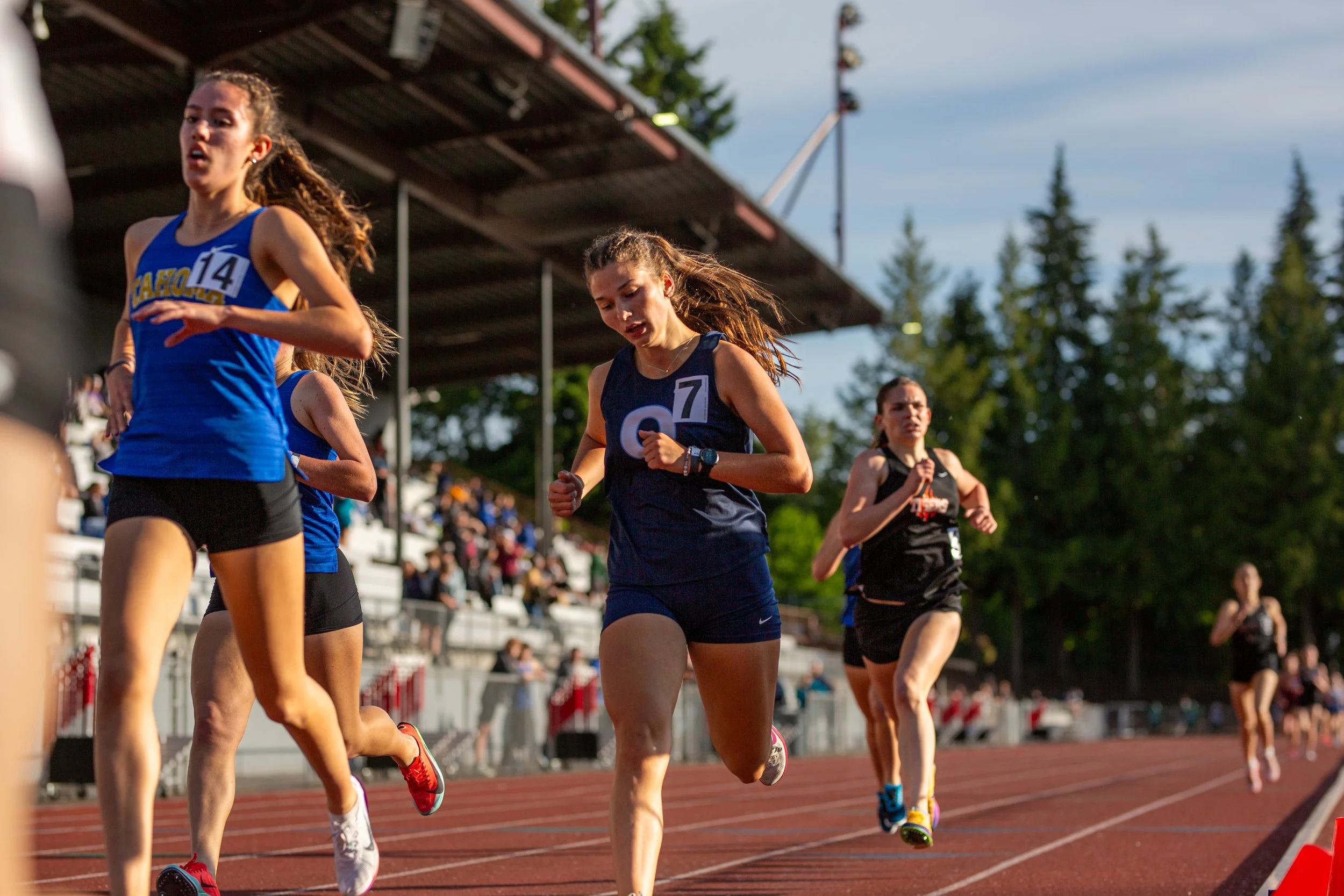 Carolina Schilter of Olympia High School finishing the 1600m at the 2025 district championships in Kent, Washington, wearing a navy Olympia singlet.