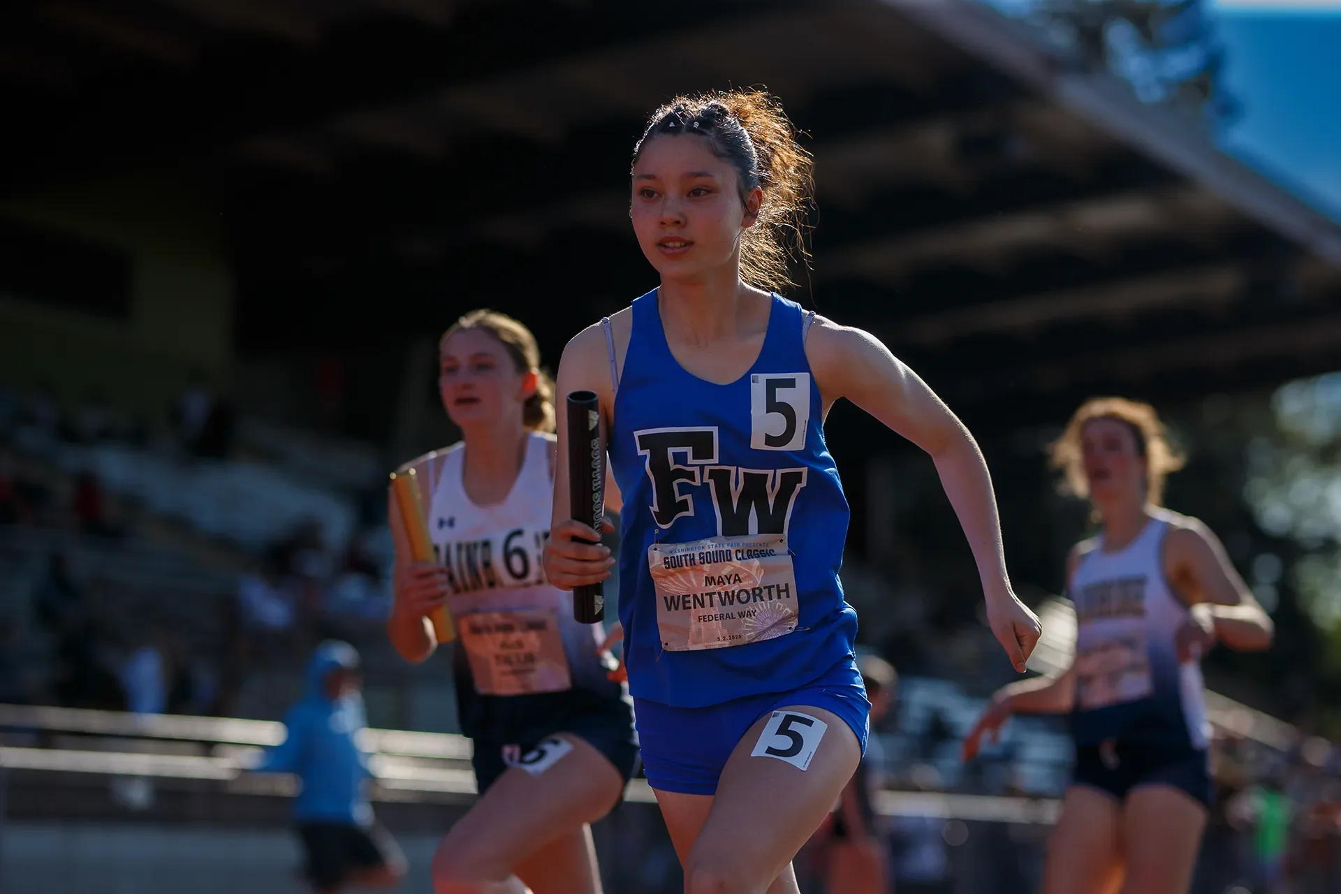 Washington high school track freshman Maya Wentworth of Federal Way High School carrying the baton during a relay event.