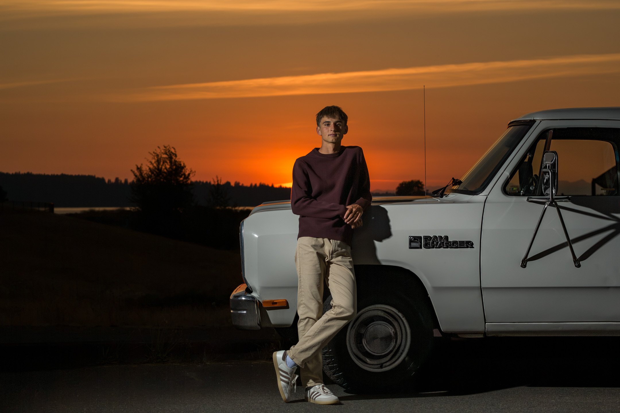 Curtis High School senior Asher Pepin leaning against a vintage Dodge Ramcharger at sunset, senior portrait session at Chambers Bay, University Place, Washington