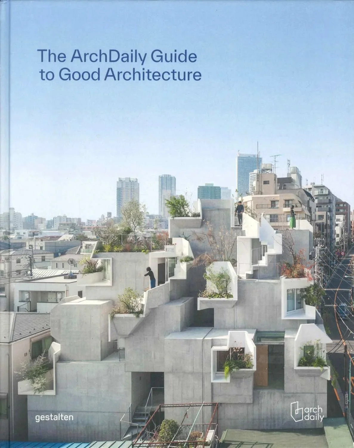 Book cover titled 'The ArchDaily Guide to Good Architecture' featuring a modern, innovative concrete building with multiple terraces, plants, and people on rooftops in an urban setting with city skyscrapers in the background.