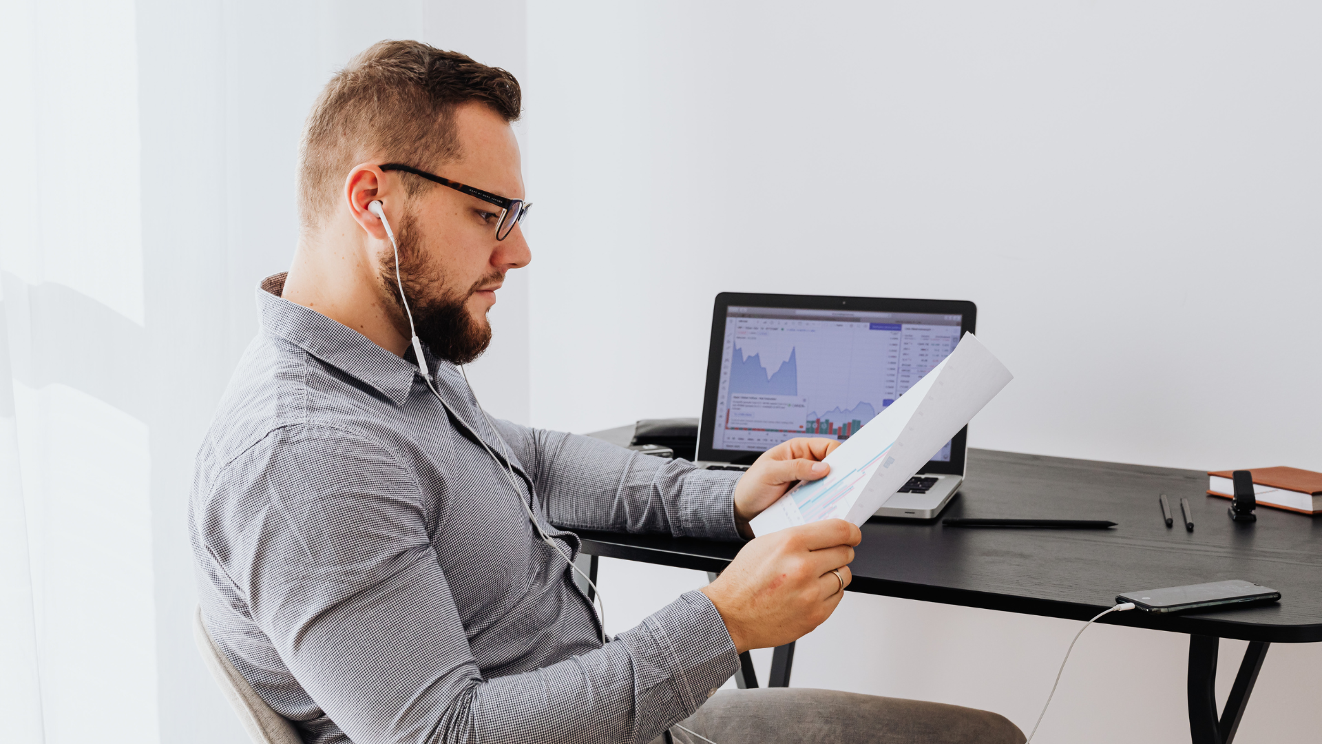 A homeowner is seated at a kitchen table, intently reviewing a solar installation proposal, indicating the importance of timing for installing solar panels.