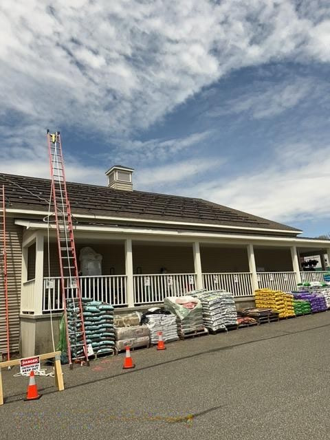 ladder propped against building for commercial solar panel installation at Carr Hardware