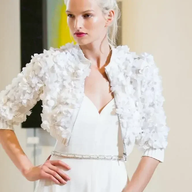 on model photography of a woman in a white cropped edge to edge jacket and white dress