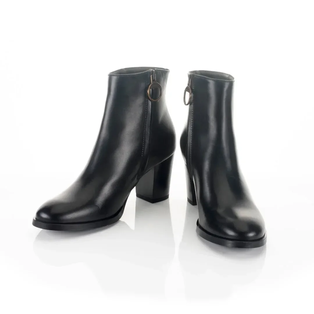 Pair of black leather ankle boots with high block heels and side zippers.