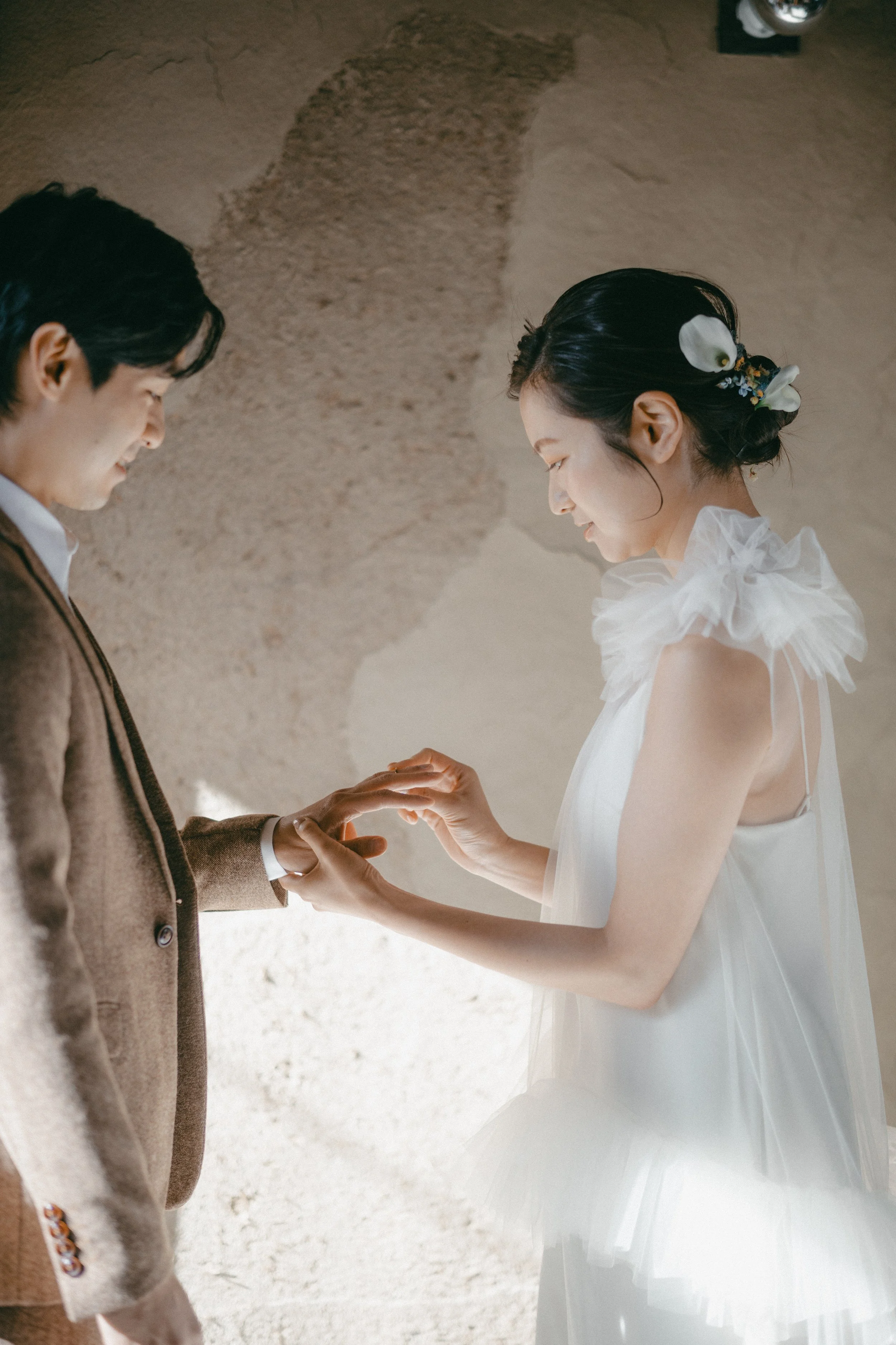 A bride and groom exchanging rings during their wedding ceremony.
