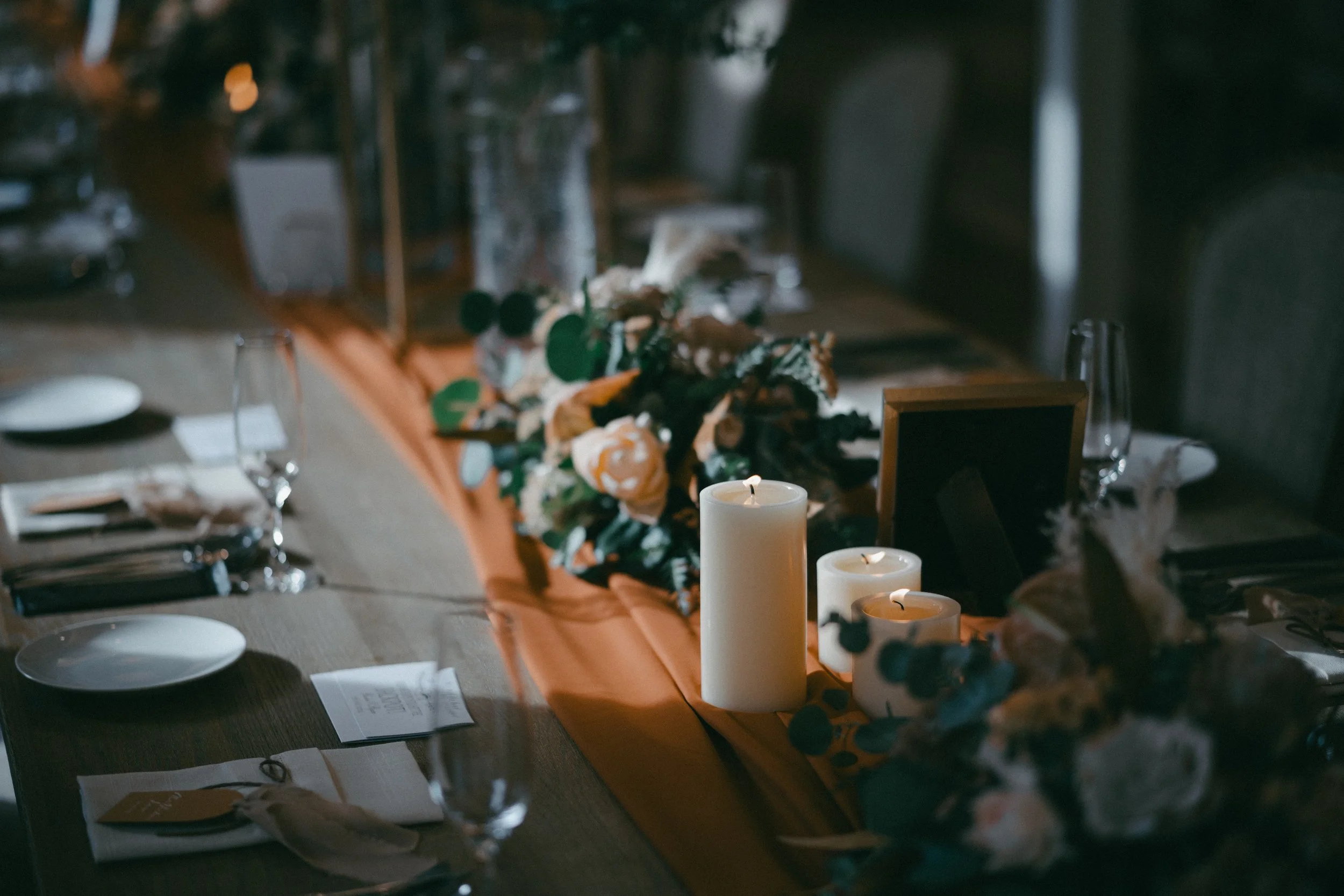 Elegant dining table decorated with candles, floral arrangements, and table settings, ready for a special event or dinner.