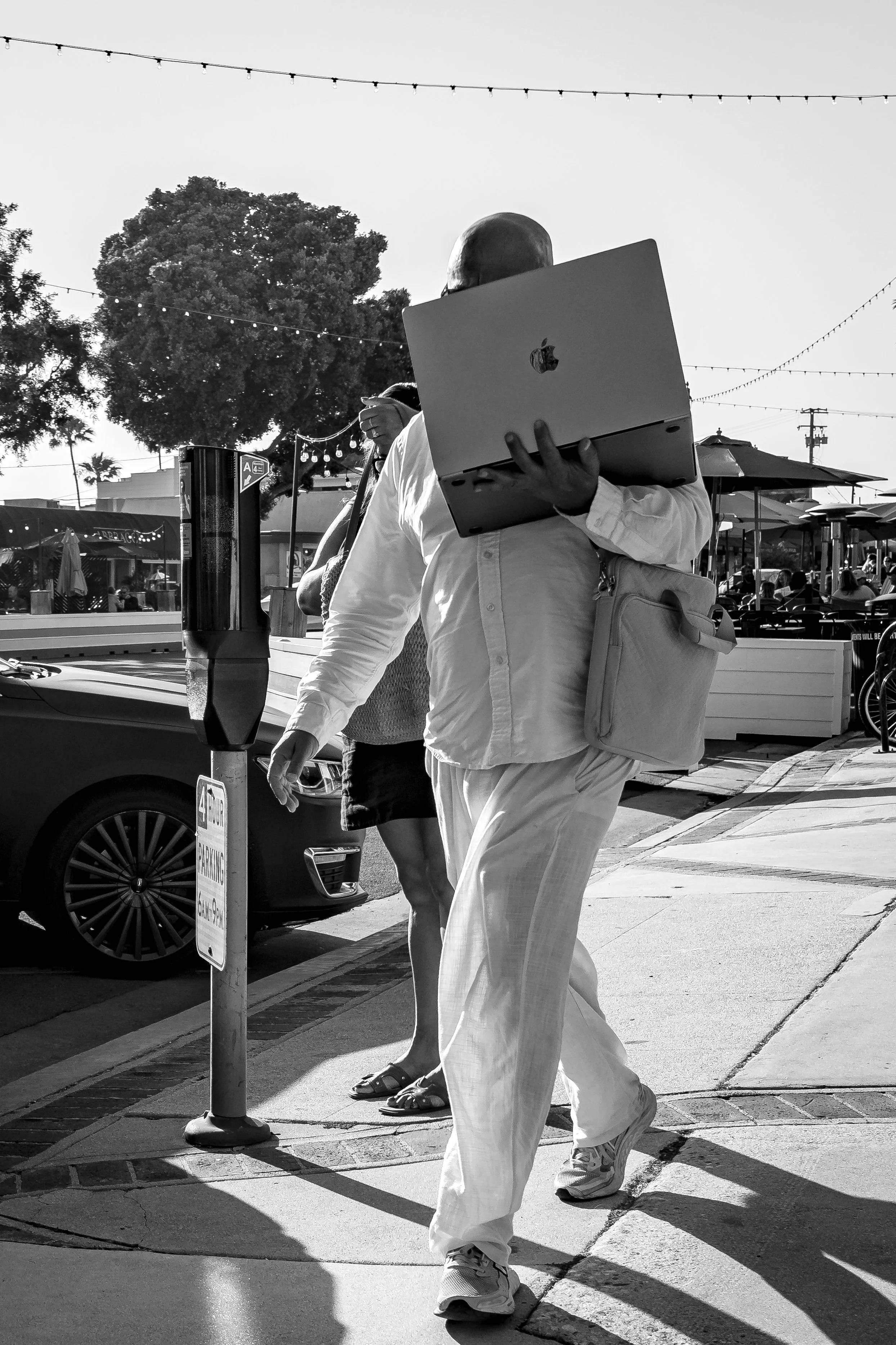 Man in white holds laptop to face bnw.jpg