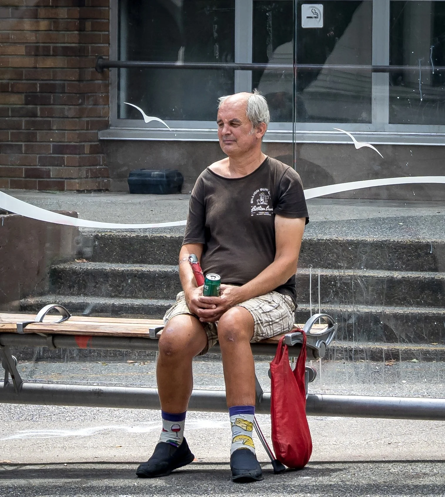 Man on bus bench between seagull decorations.jpg